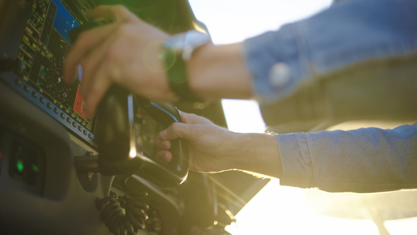 Pilot's hands adjusting controls in airplane cockpit