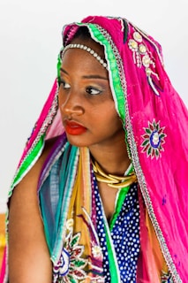 Woman in vibrant traditional clothing and headscarf.