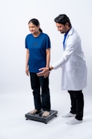 Doctor assisting patient on a scale.