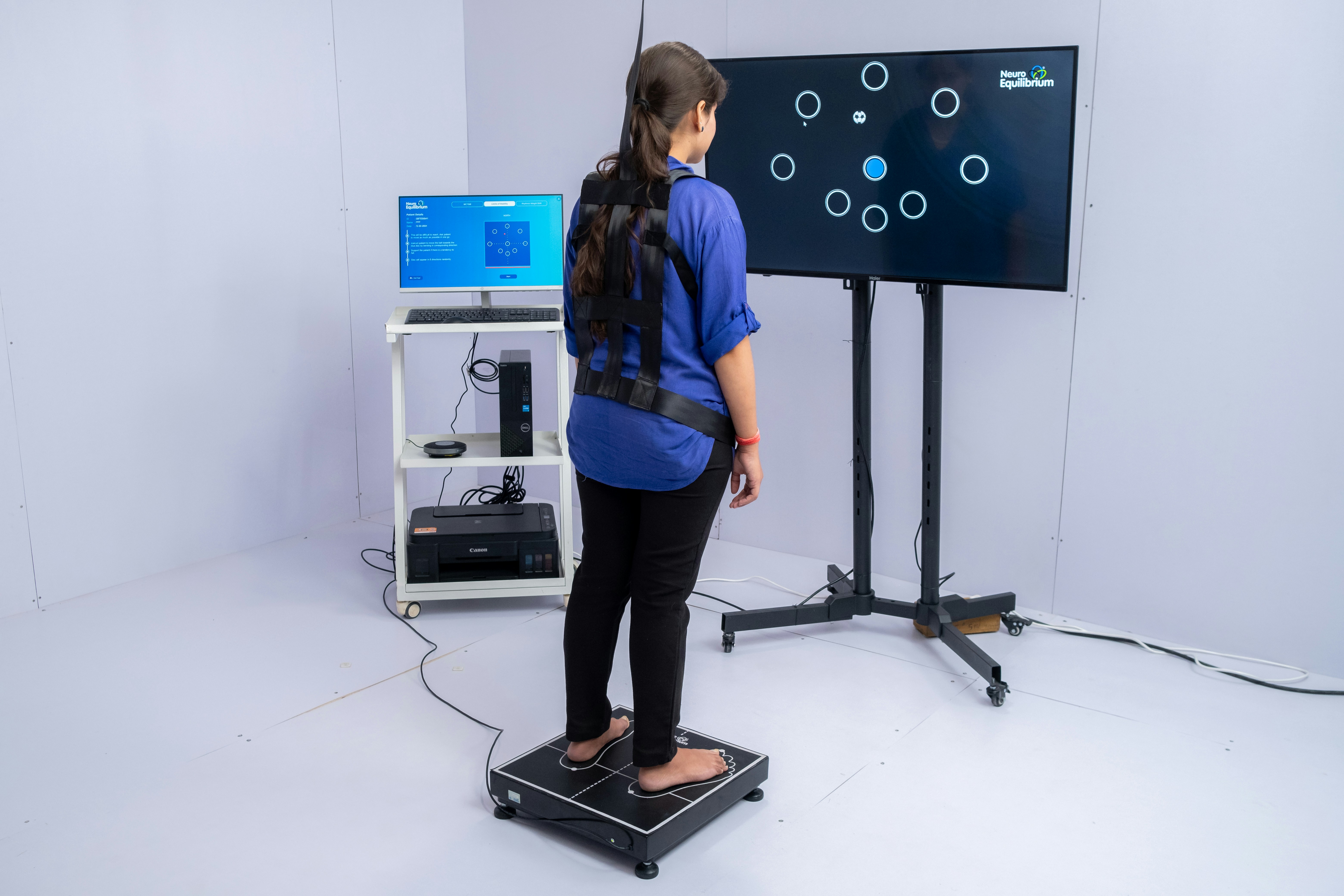 Woman stands on pressure plate with sensors on-screen interactive game.