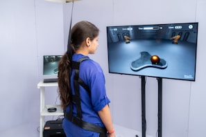 Woman wearing harness interacts with virtual reality game.