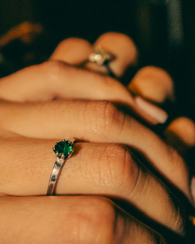 Adult woman's hand wearing a fine emerald ring