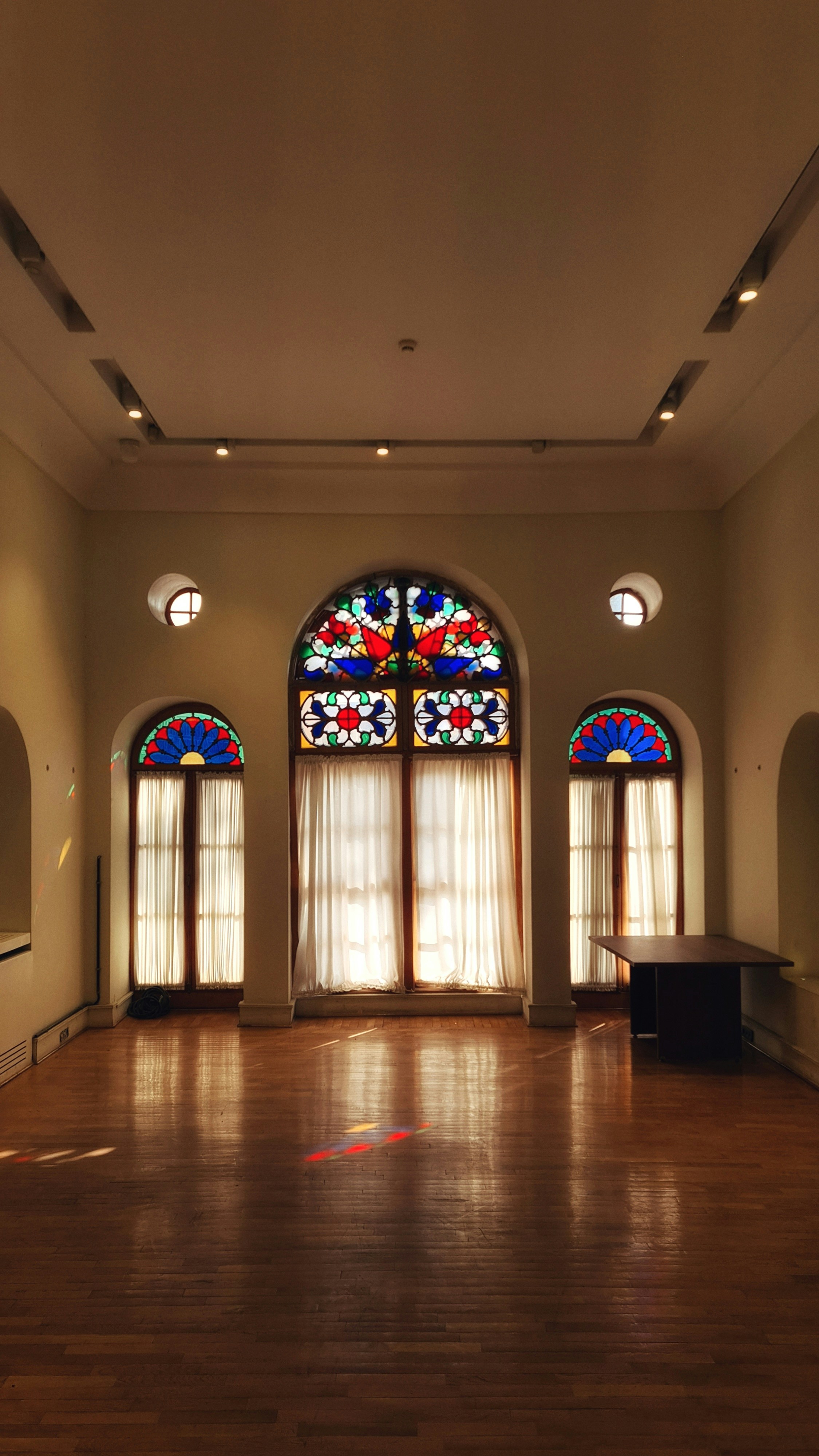 Habitación interior con vidrieras y suelo de madera