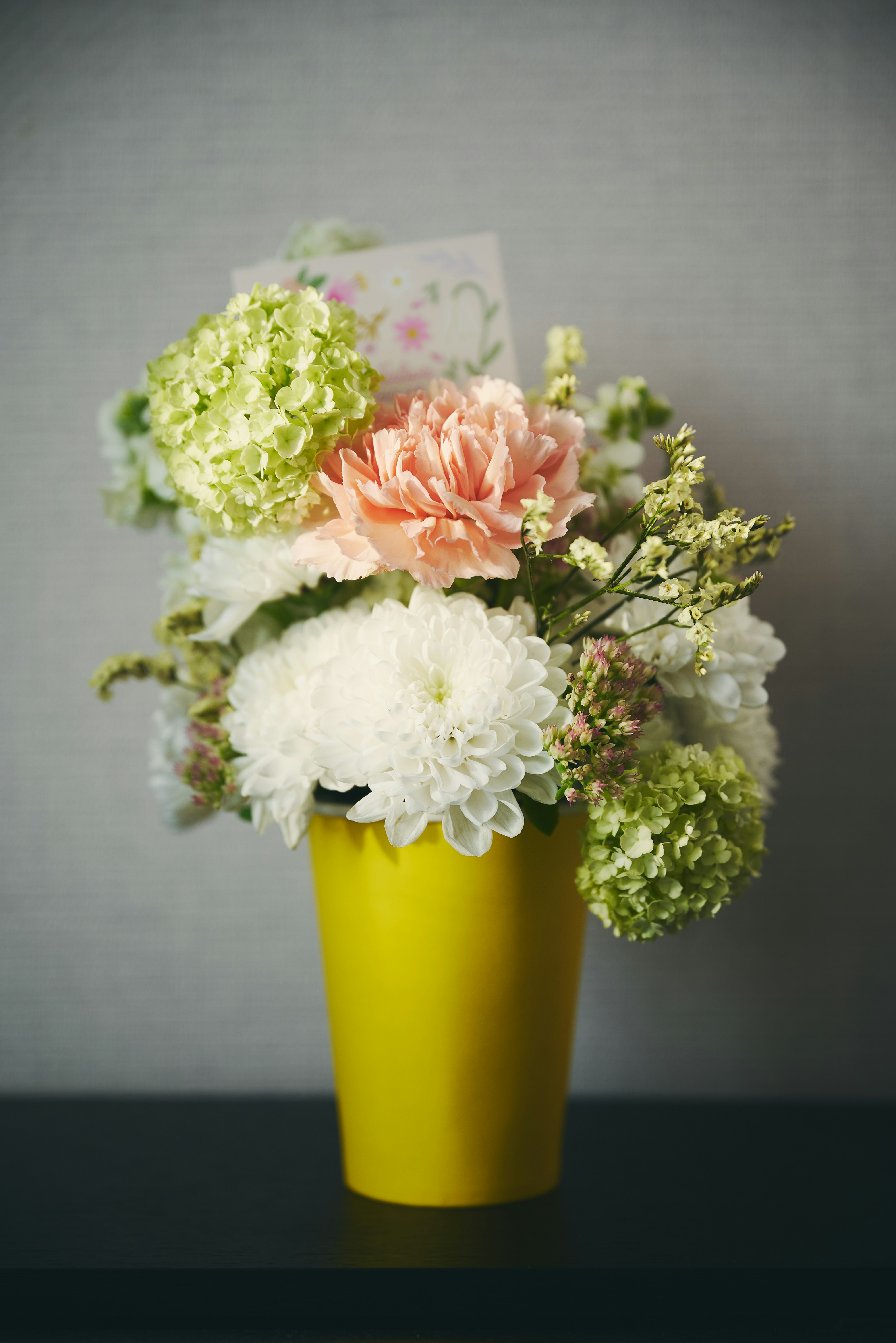 A bouquet of flowers in a yellow vase.