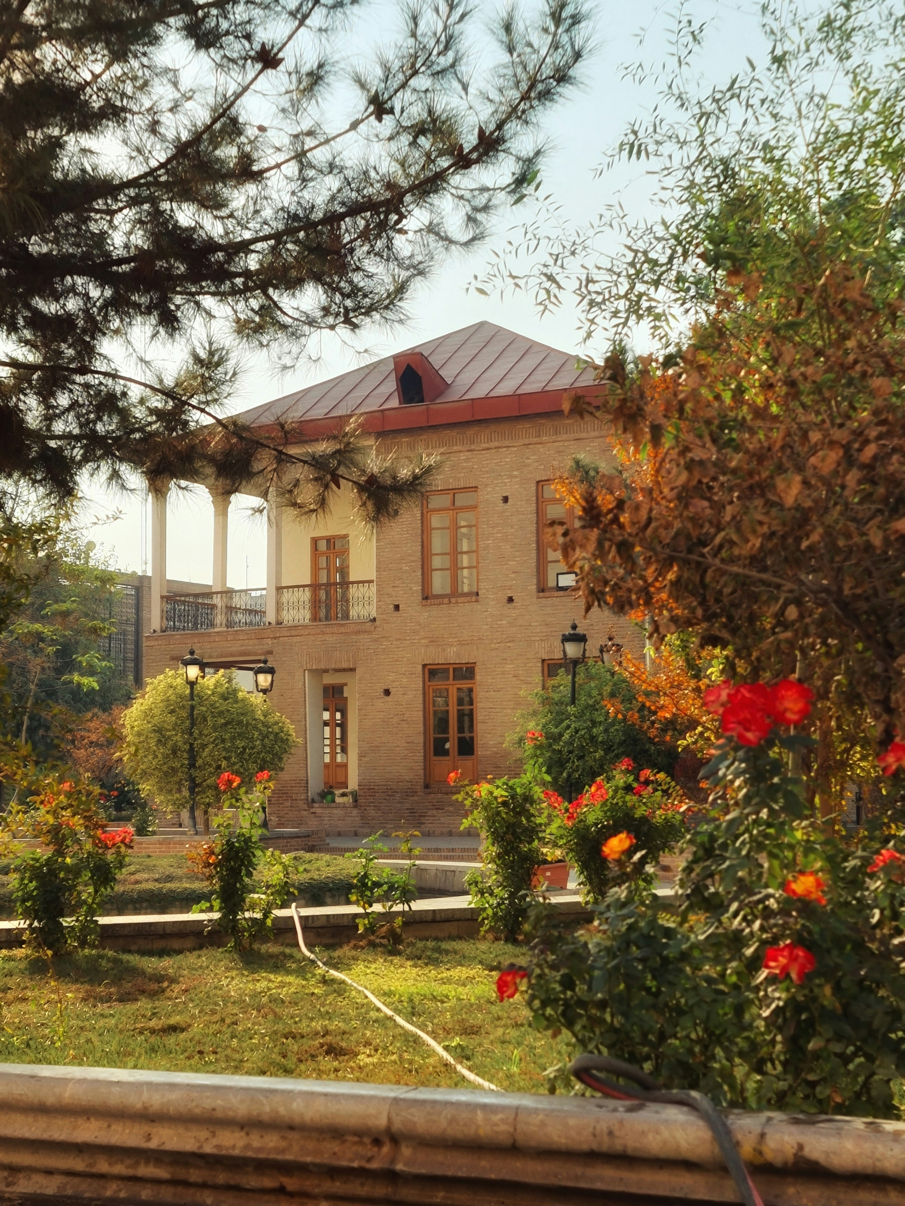 Una casa de ladrillo con balcón y jardín.
