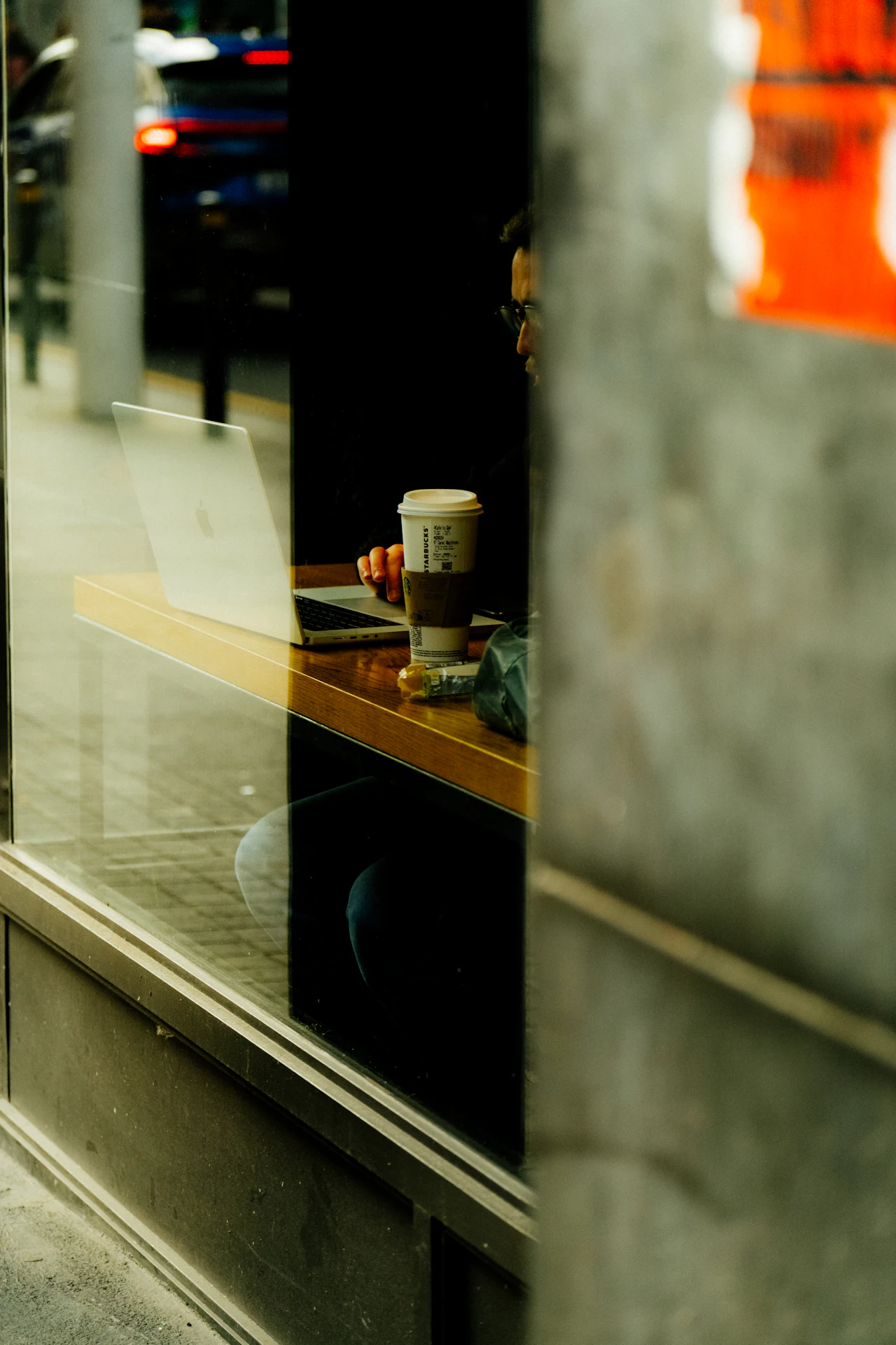 A laptop and a coffee on a sunlit cafe counter, the kind of place independent work actually happens.