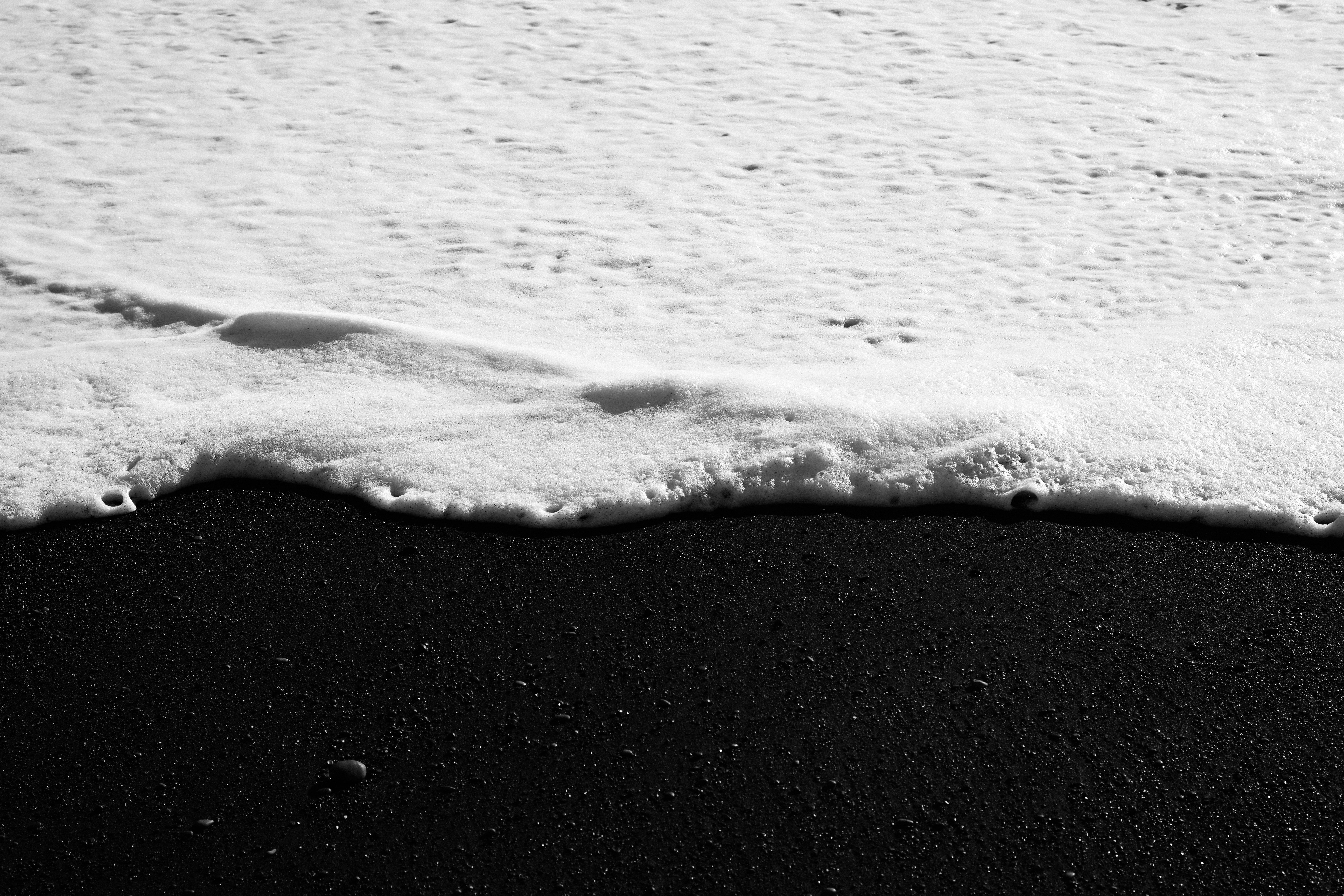 Black sand beach with foamy ocean waves