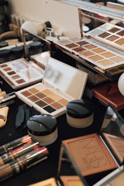 Assortment of makeup palettes and products on a table.