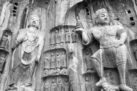 Ancient stone carvings of buddhist figures on cliff face