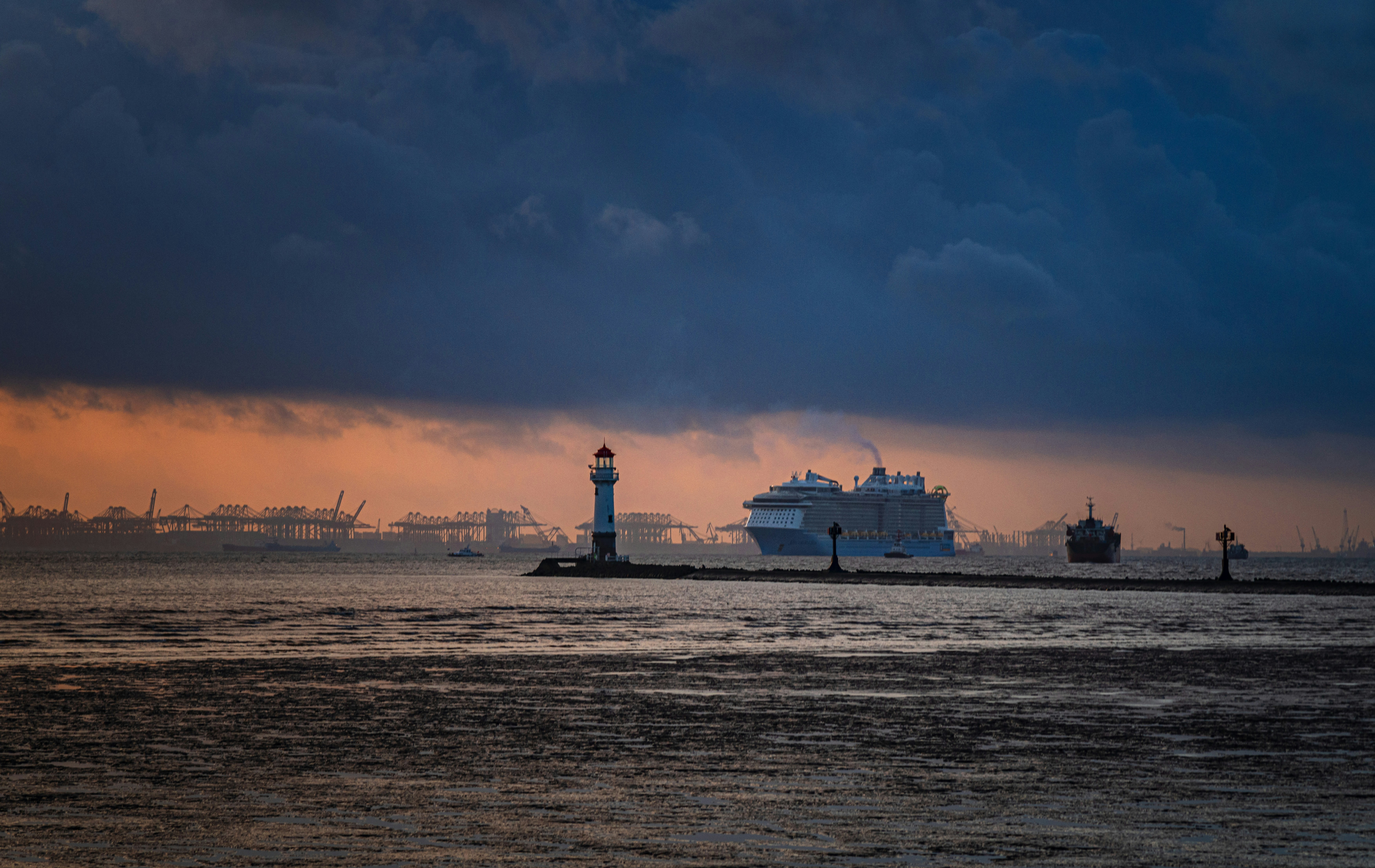 夕暮れ時に灯台のそばを通過するフェリーボート