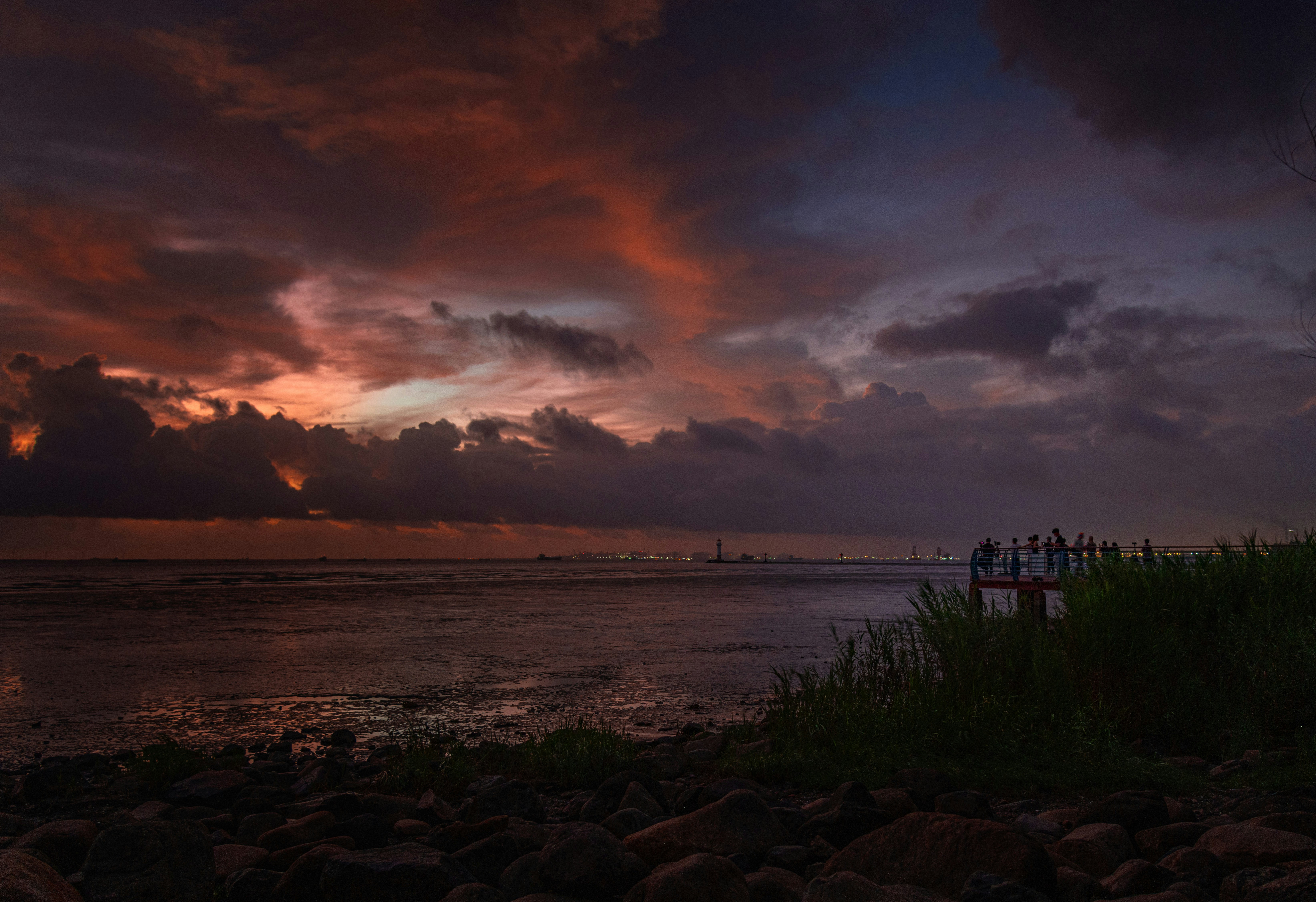 海に沈む劇的な夕焼けとシルエットの姿。