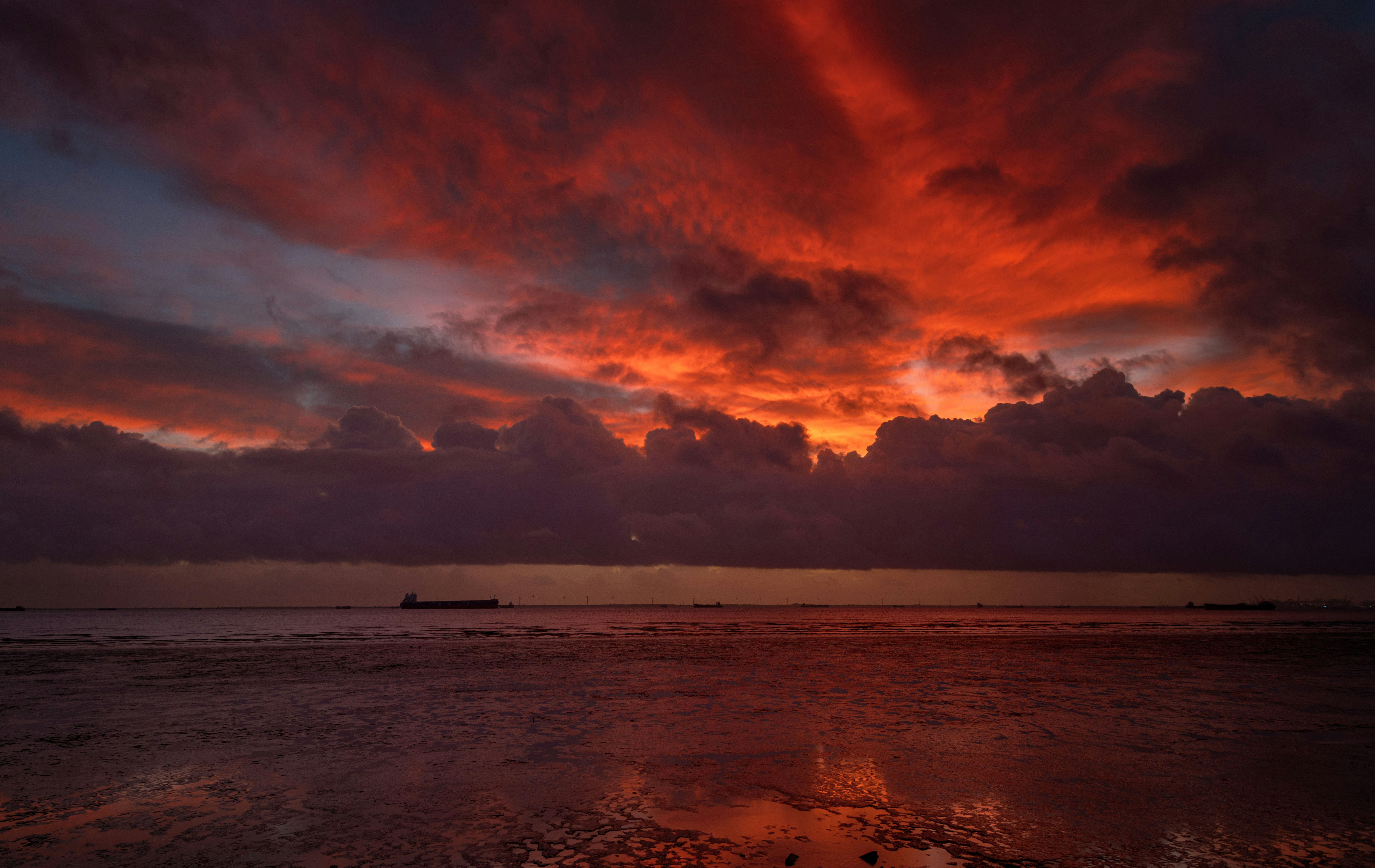 雲が広がる穏やかな海の上、劇的な夕焼け