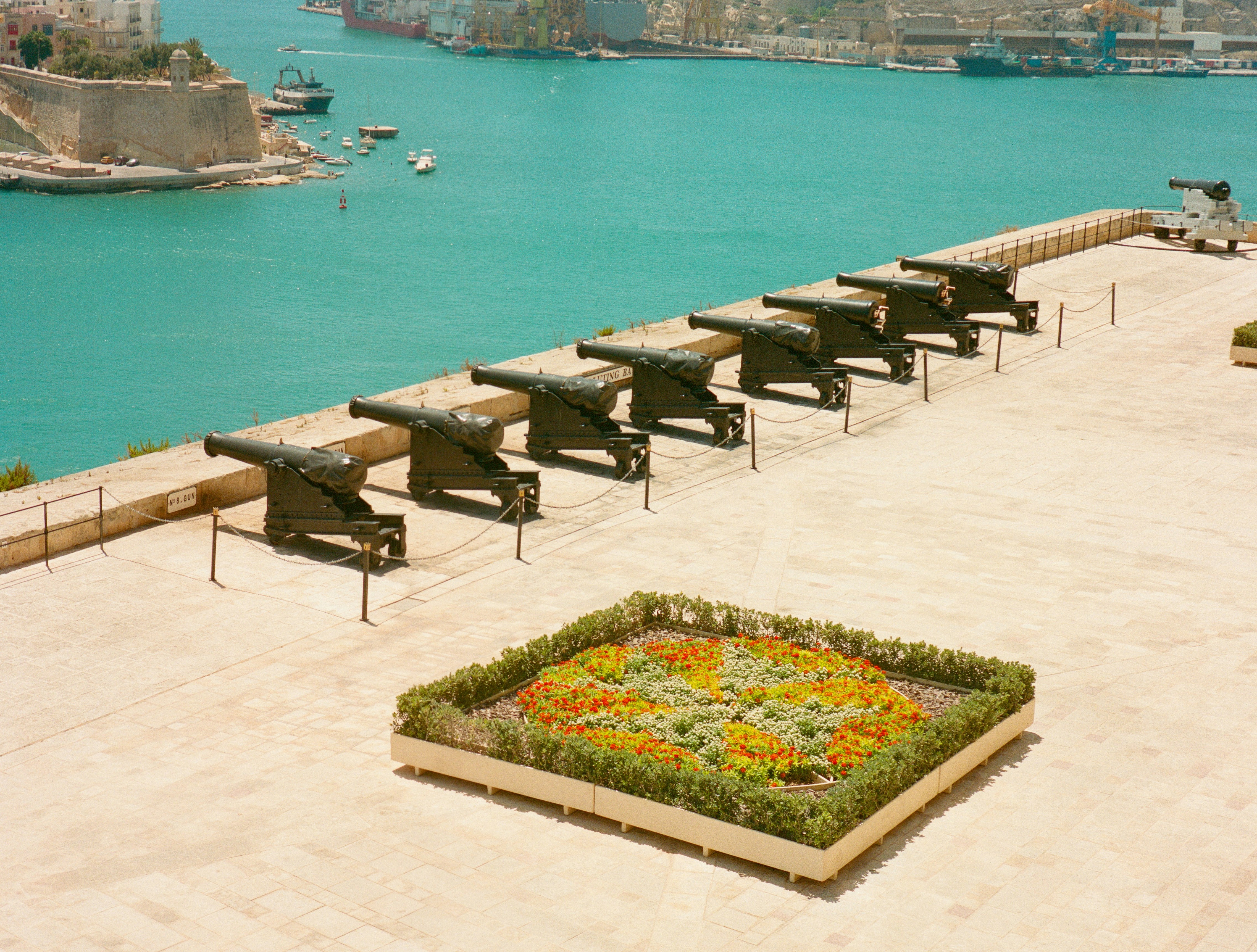 港を見下ろす大砲の列と都市の建物。