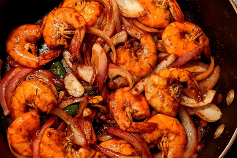 Ghee-roast prawns tossed with onions and red masala