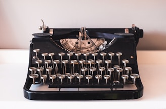 A vintage black typewriter on a white surface.