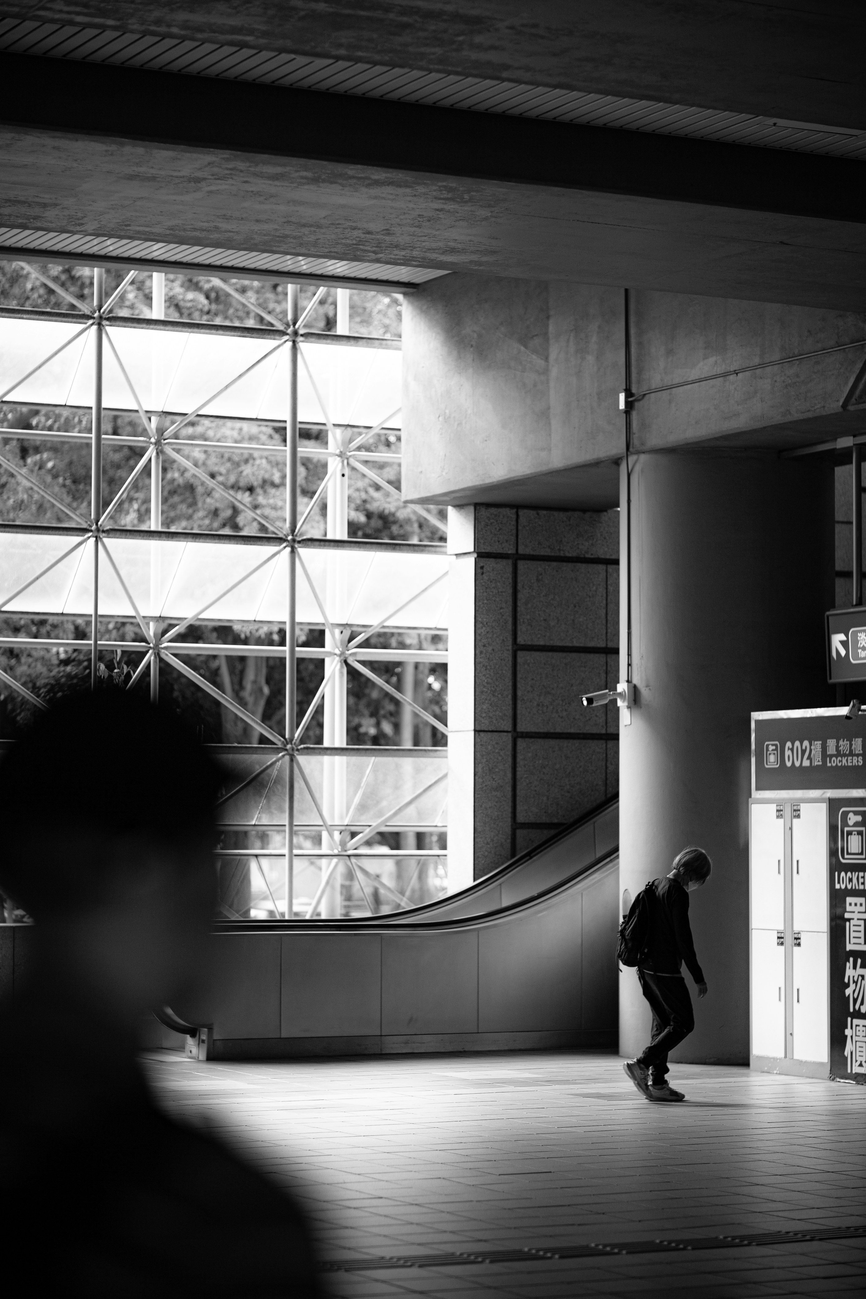 Man walking in a modern, abstract urban station.