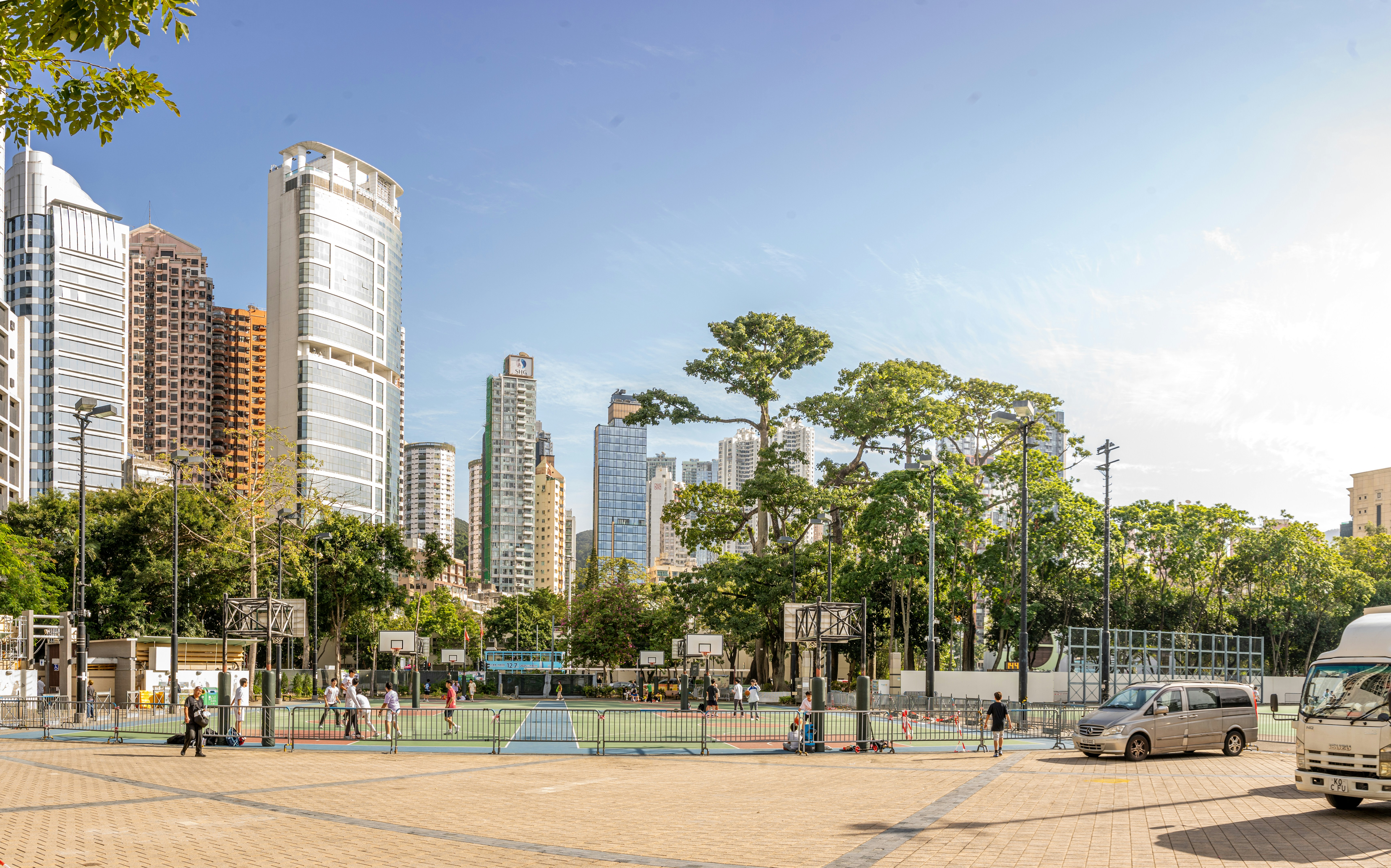parc municipal avec des terrains de basket et des gratte-ciel.