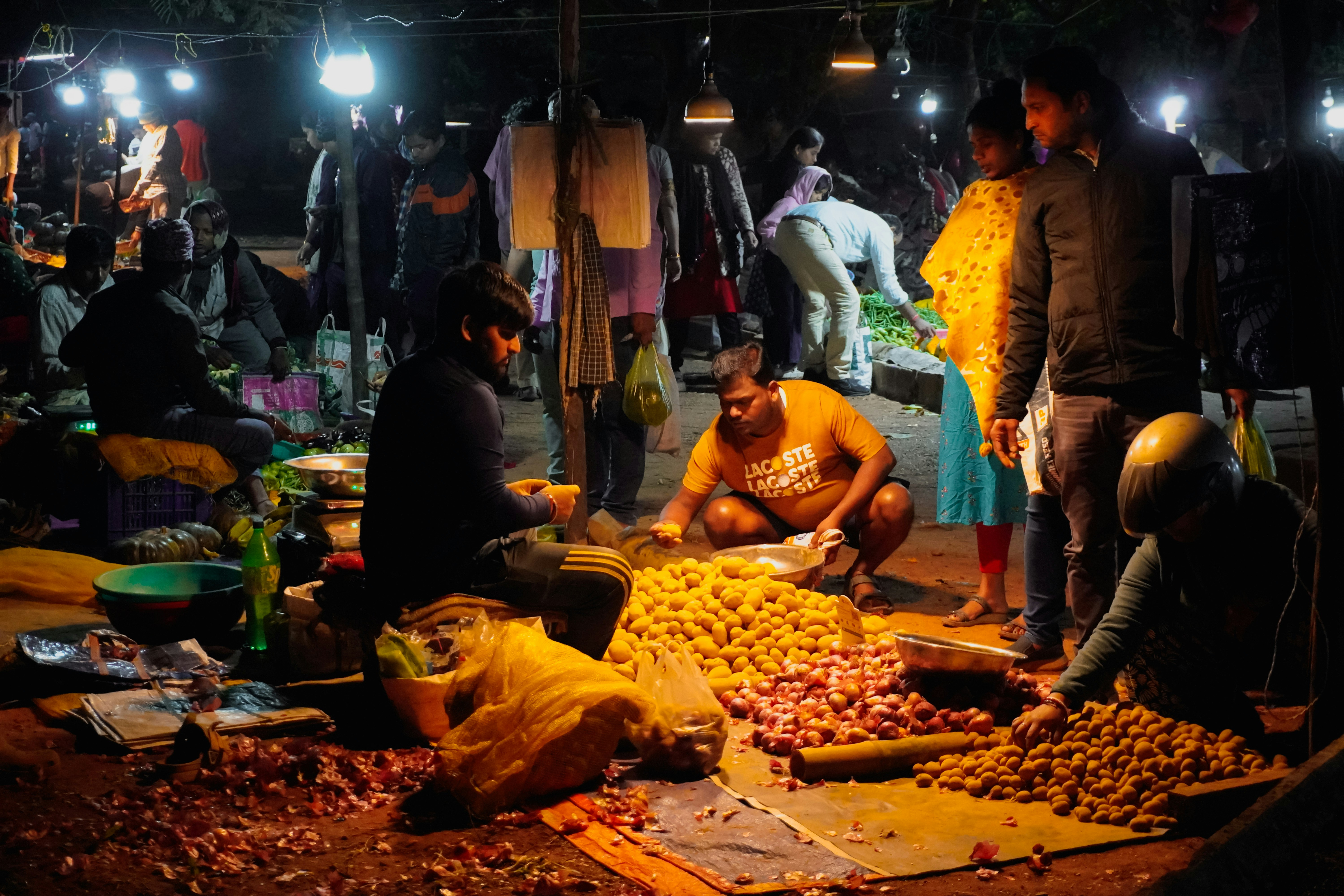 People shopping at a busy night market stall.