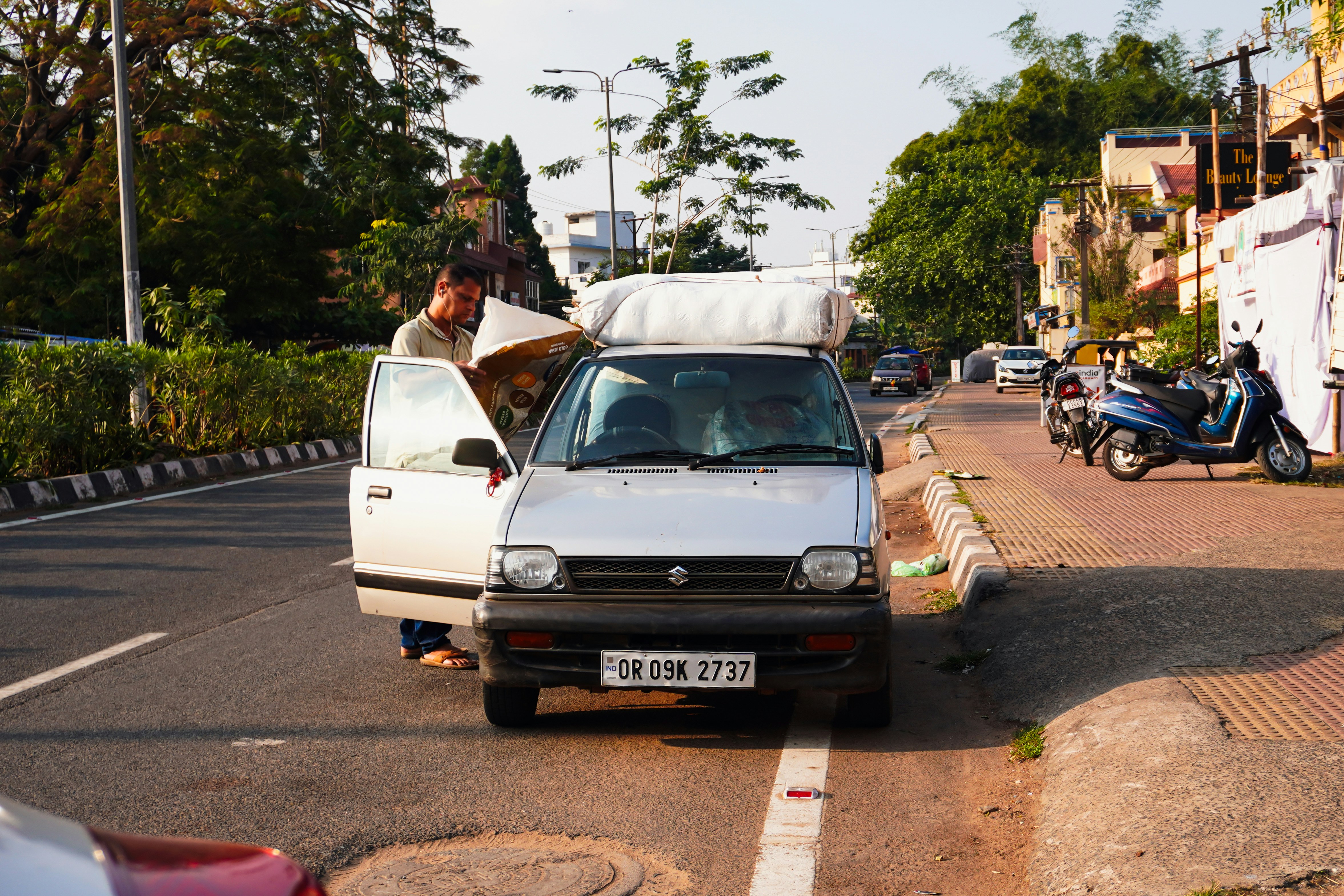 Man loading luggage onto a silver car