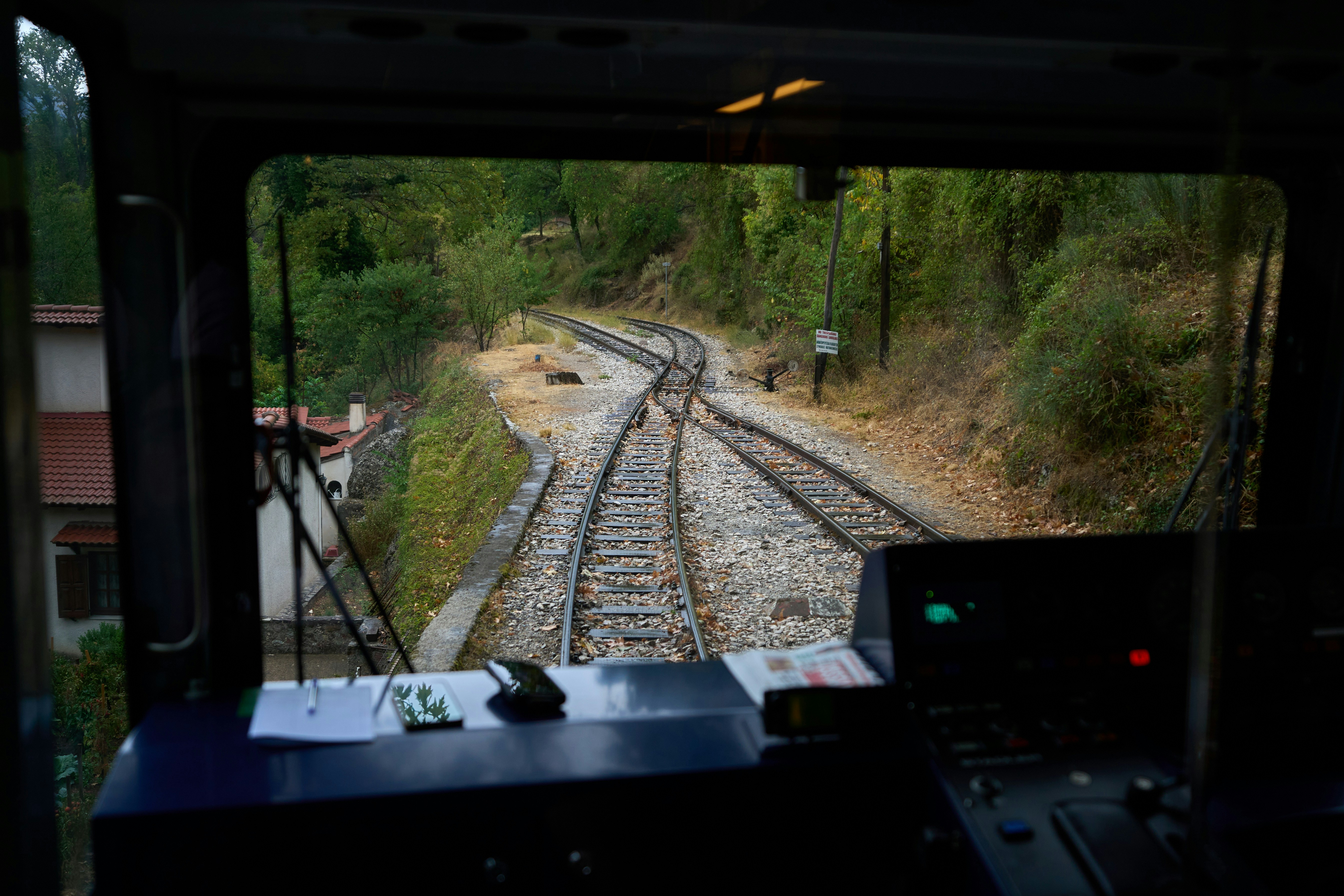 View from train cabin of diverging railway tracks.