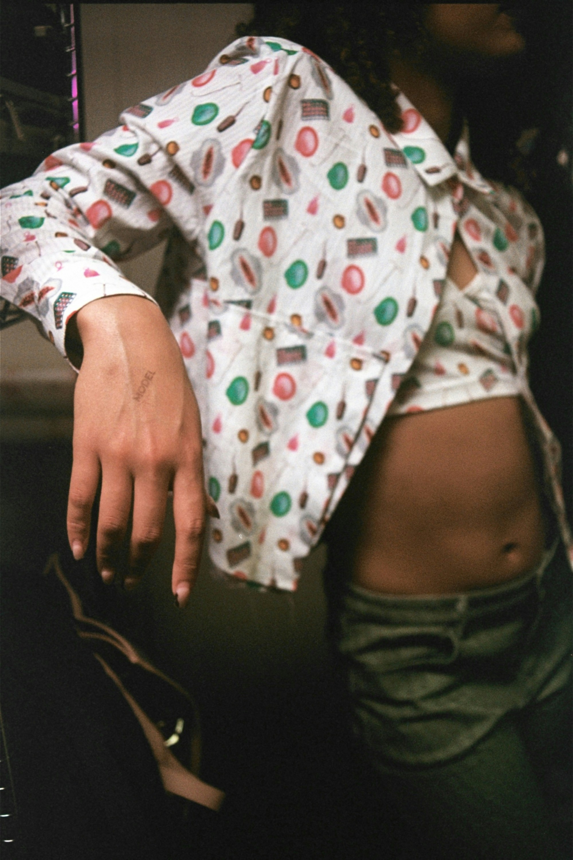 Woman in patterned jacket and crop top.