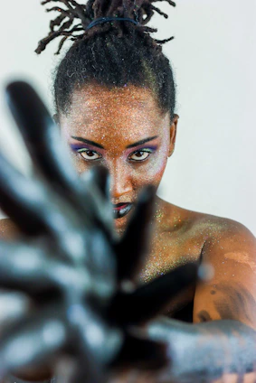 Woman with glitter makeup reaching forward