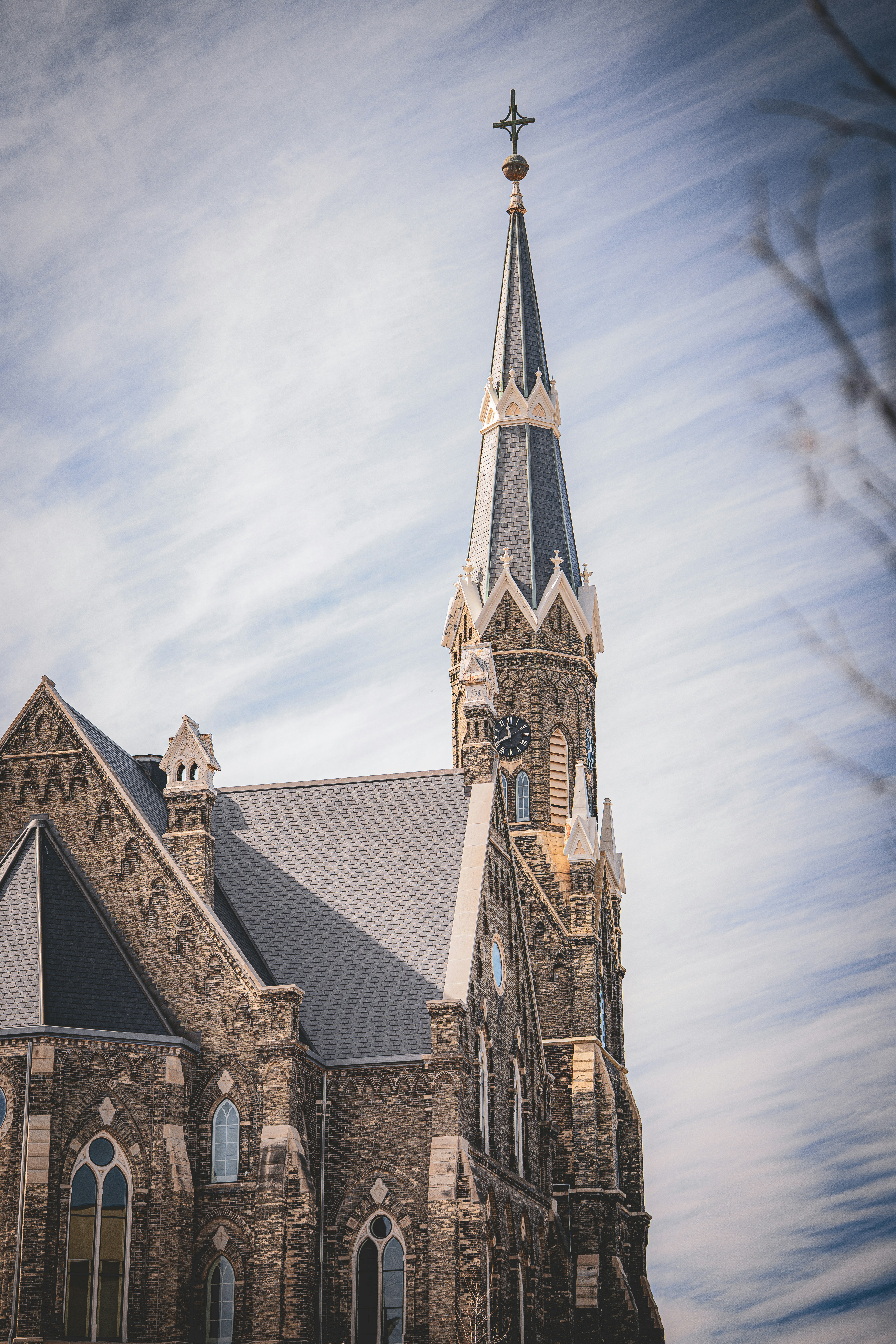 Stone church steeple against a cloudy sky