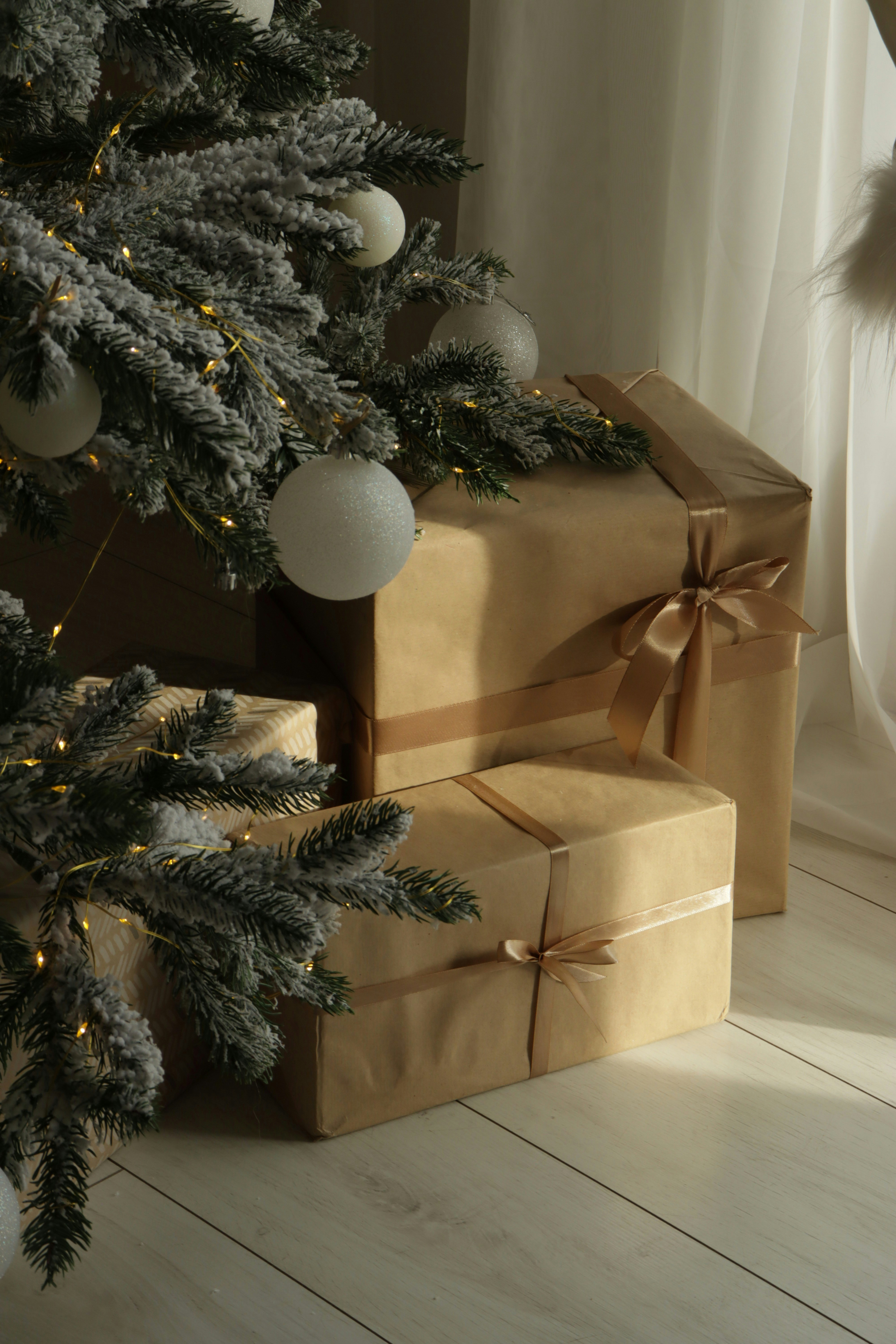 Christmas tree with gifts wrapped in brown paper.