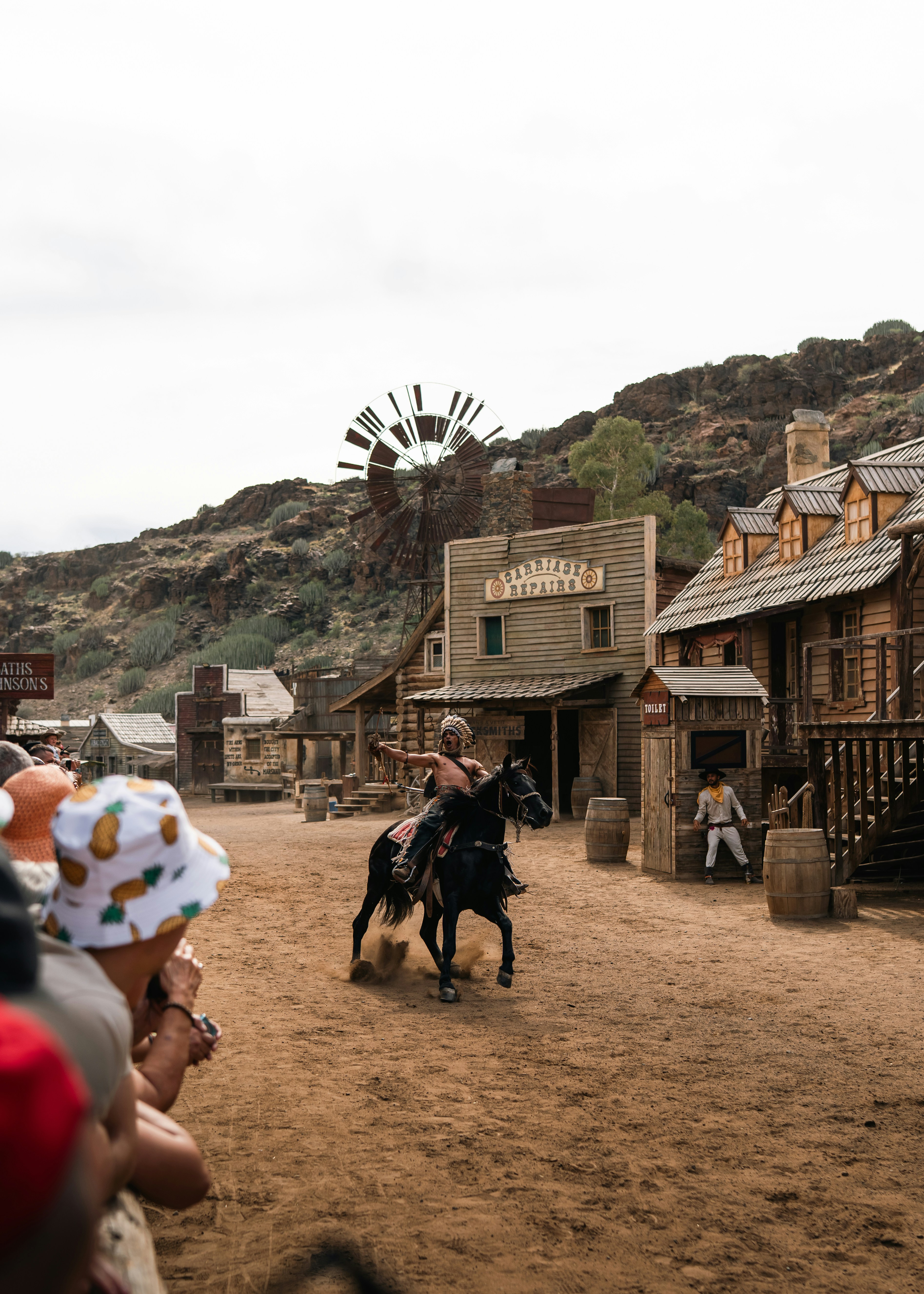 Cowboy rides horse through old western town
