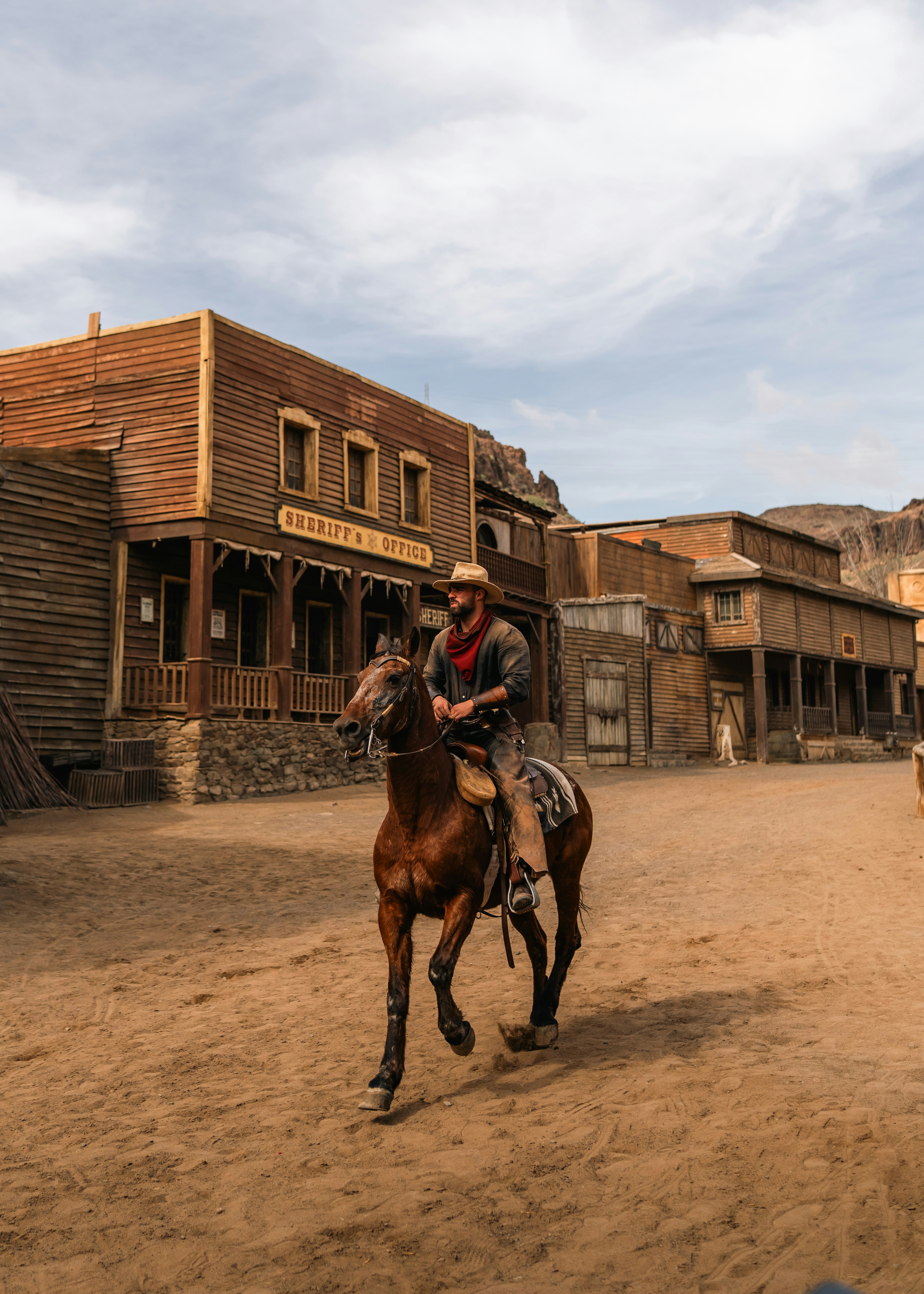 Cowboy reitet auf Pferd durch die alte Westernstadt