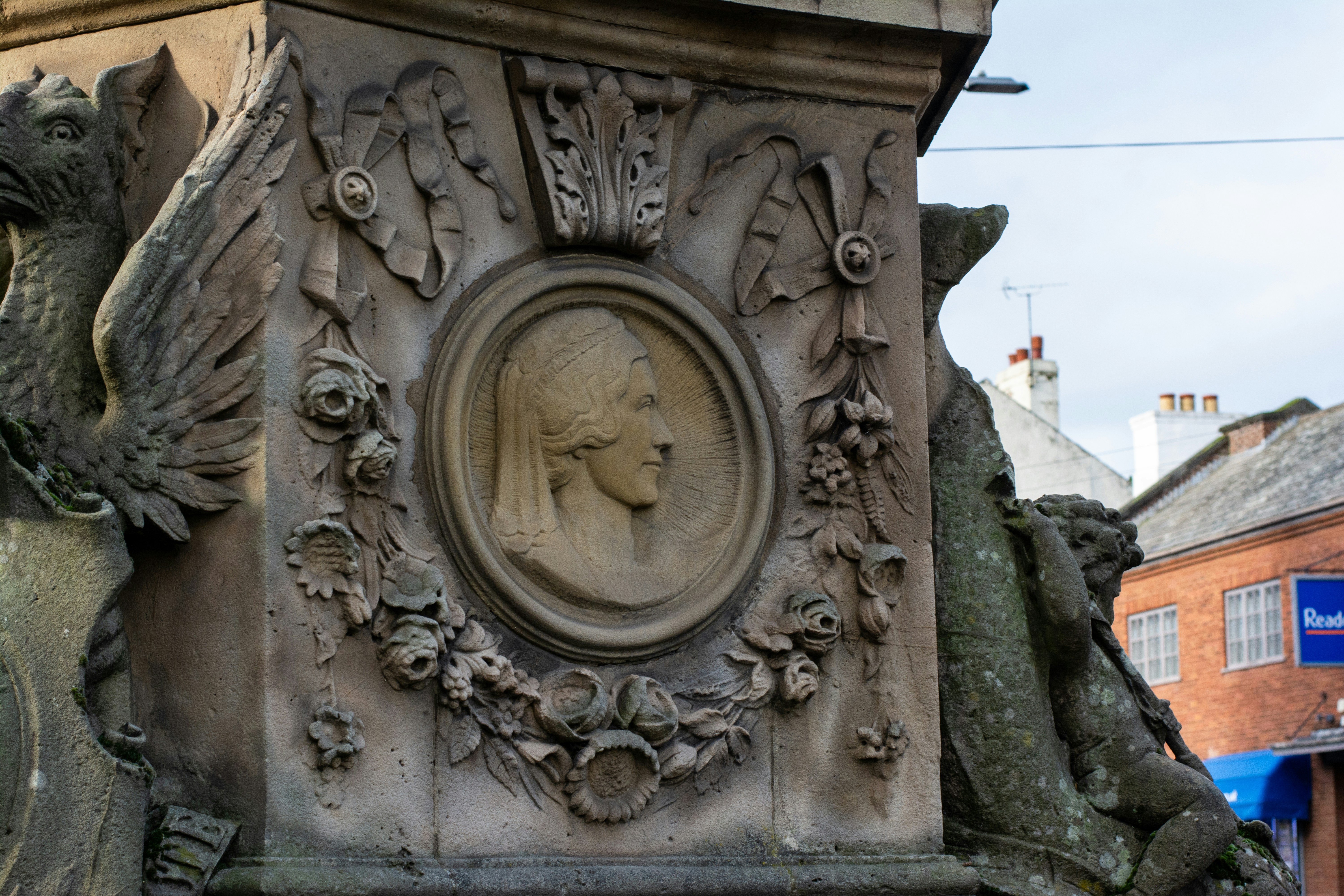 Stone relief of a profile portrait surrounded by ornamentation.