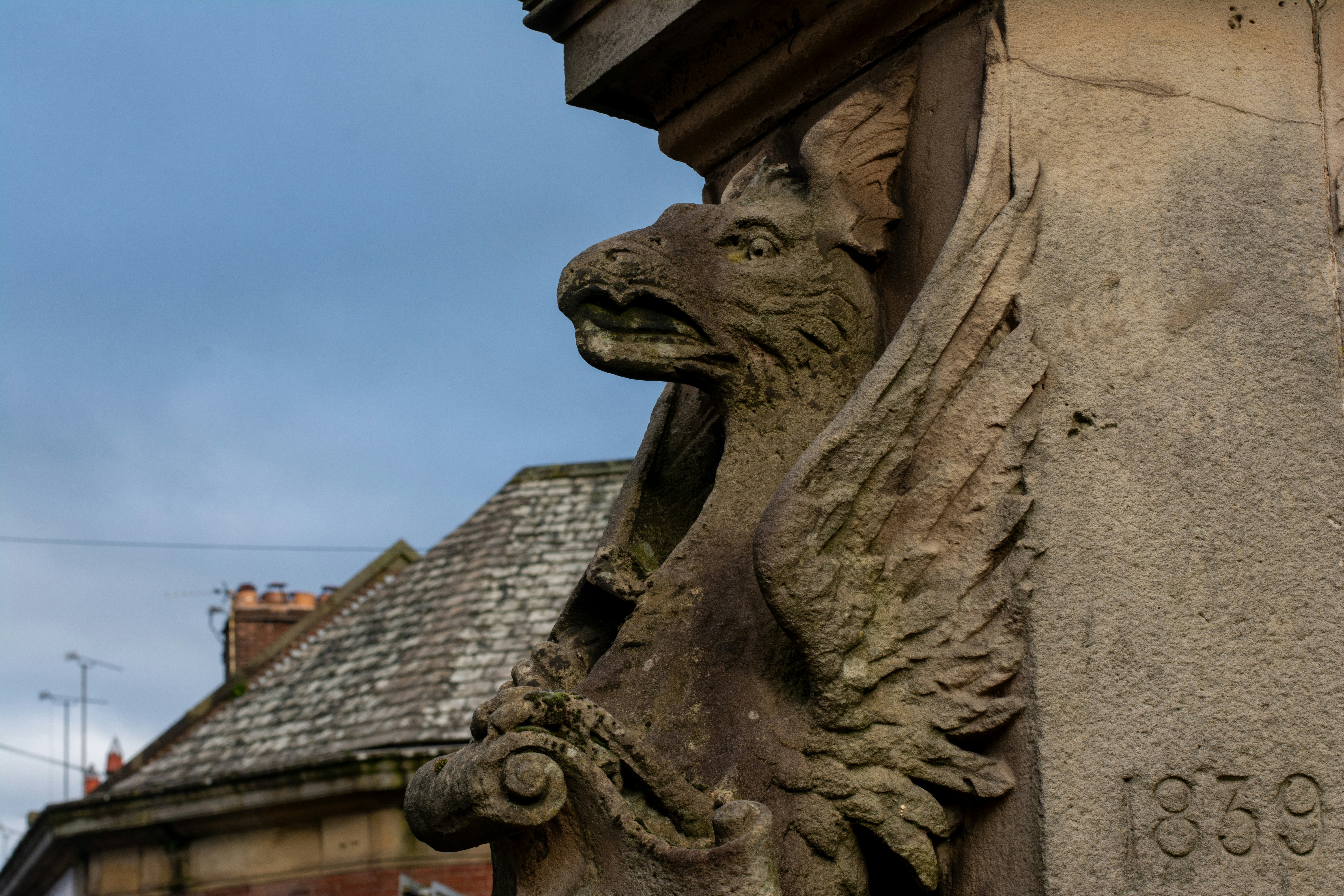 Steingreif-Skulptur an einer Außenfassade eines Gebäudes.
