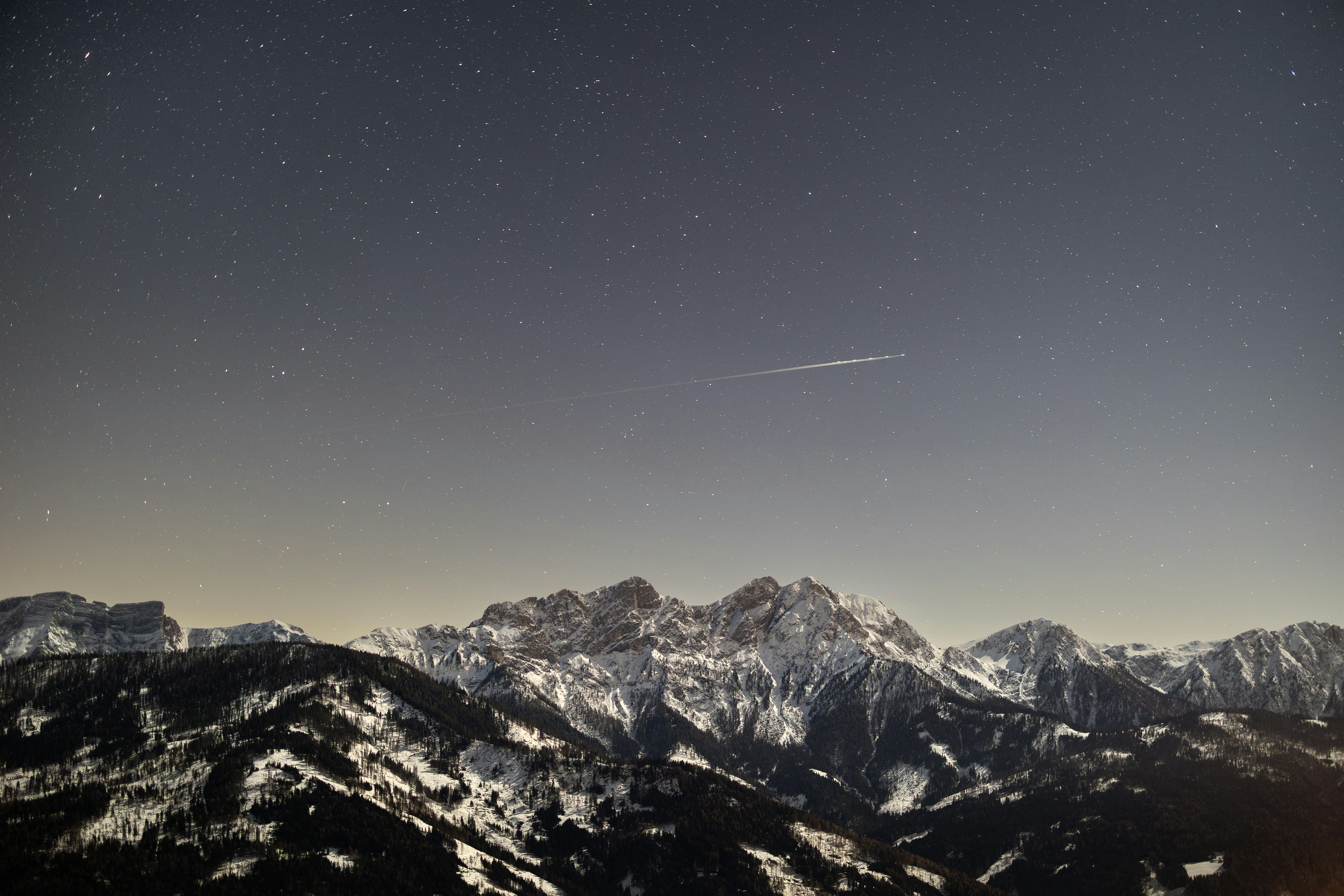 Starry night sky over snow-covered mountains