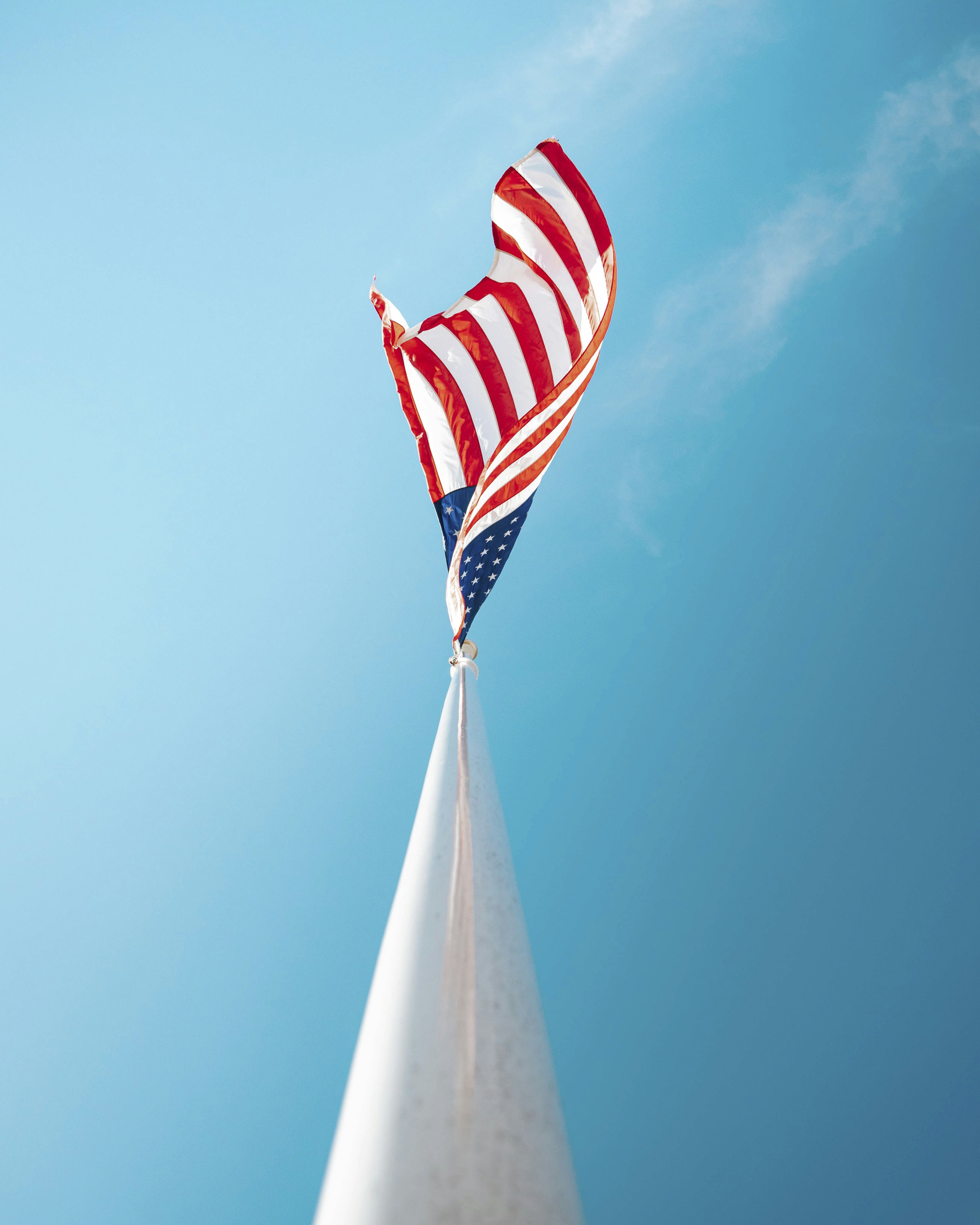 American flag waving against a clear blue sky