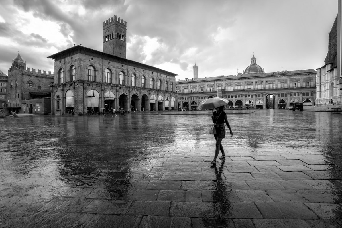 Bologna February — rain-soaked Piazza Maggiore with reflections on the cobblestones