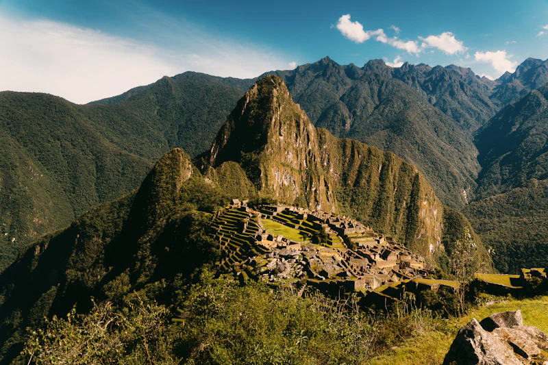 Machu Picchu seen from above, the stone city nestled among lush green Andean peaks