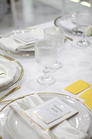 Elegant table setting with wedding invitations and glassware