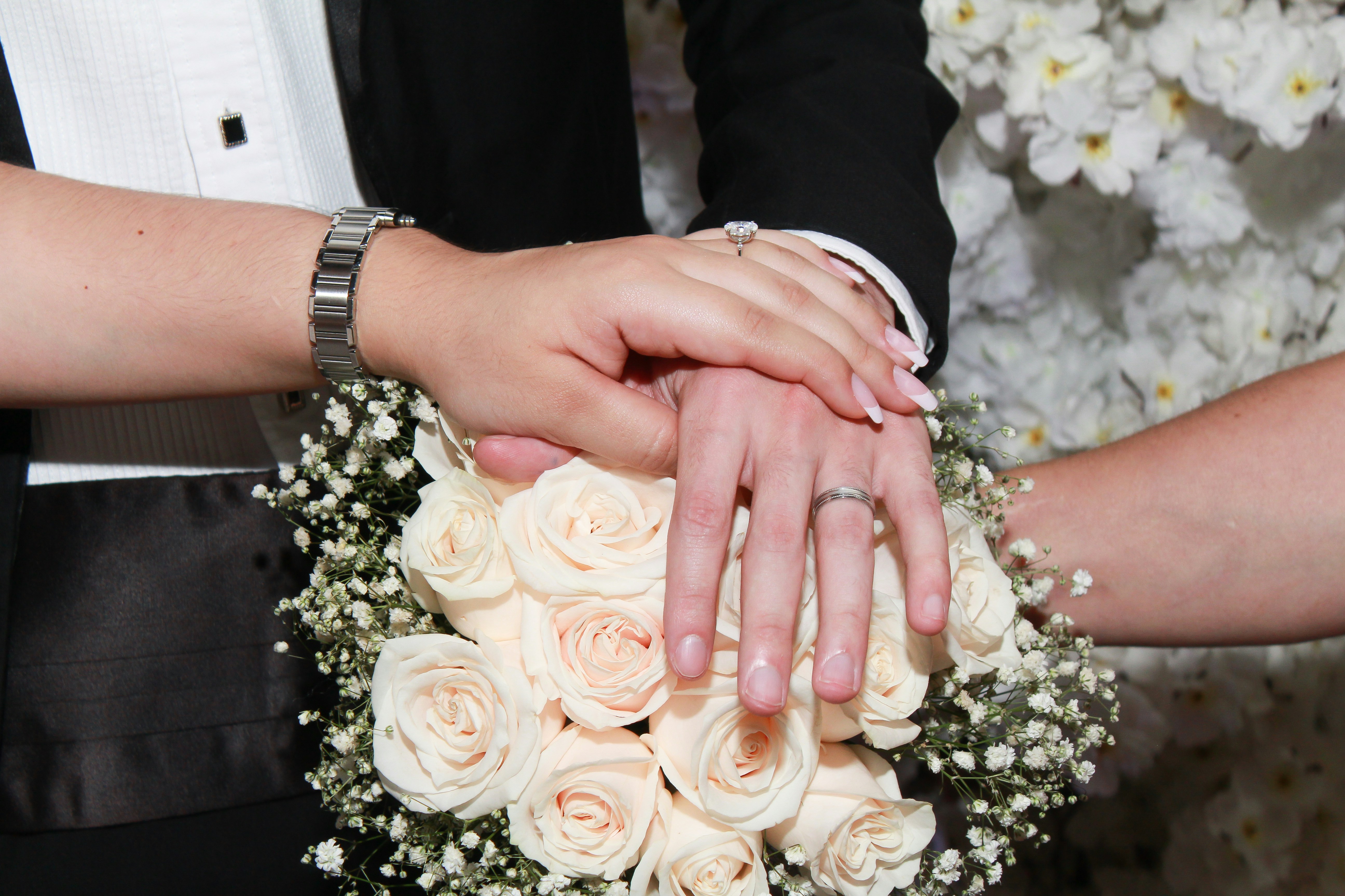 Wedding rings flowers, Wedding planner notebook, Couple holding hands, ilustrasi artikel Stress-Free Wedding Budgeting: Your Ultimate Guide to a Joyful Day 2