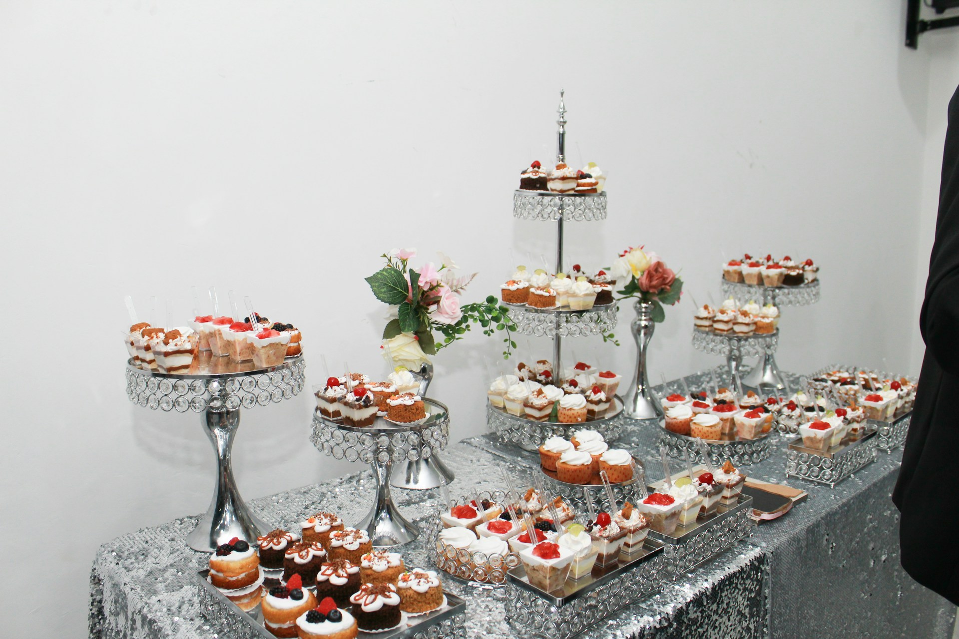 Dessert table with numerous cupcakes and pastries.