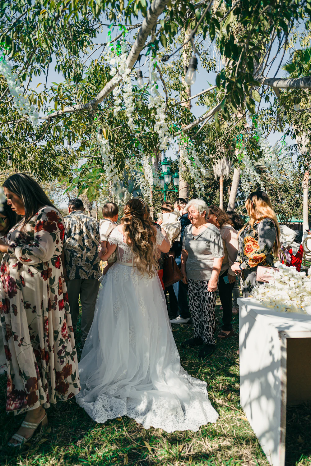 Bride holding her veil outdoors with a guest