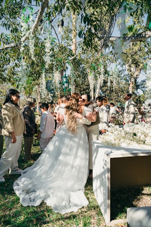 Bride hugging guests at outdoor wedding ceremony