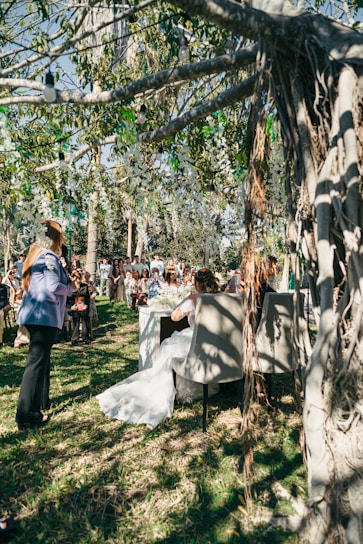 Bride sitting at table during outdoor wedding ceremony