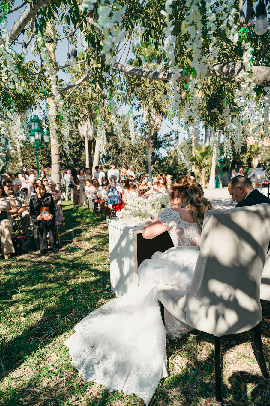 Bride and groom at an outdoor wedding ceremony, natural light and garden greenery surrounding them