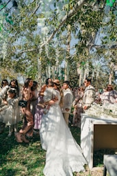 Bride hugging guests at outdoor wedding ceremony