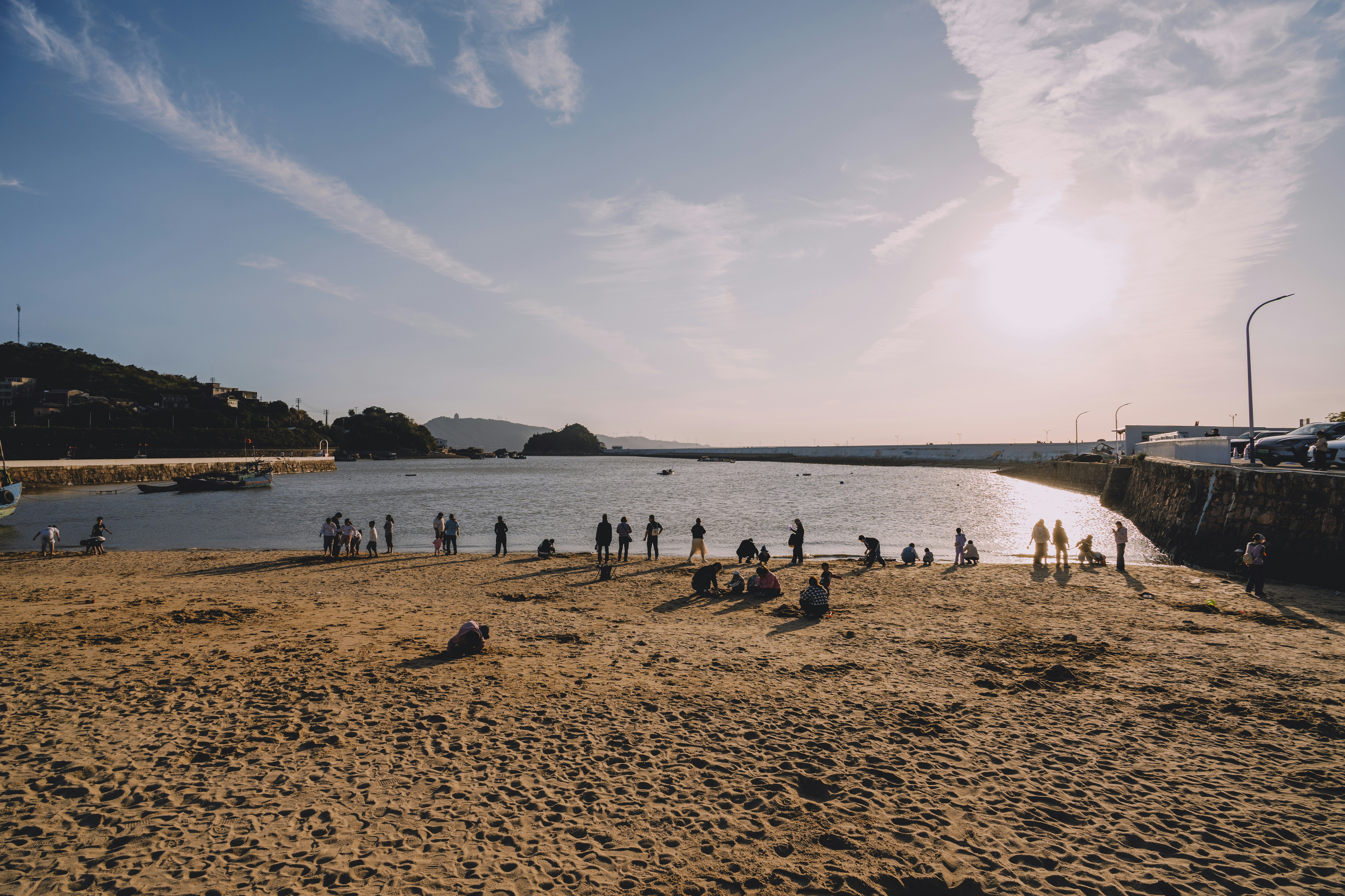 People gathered on a sandy beach by the water.
