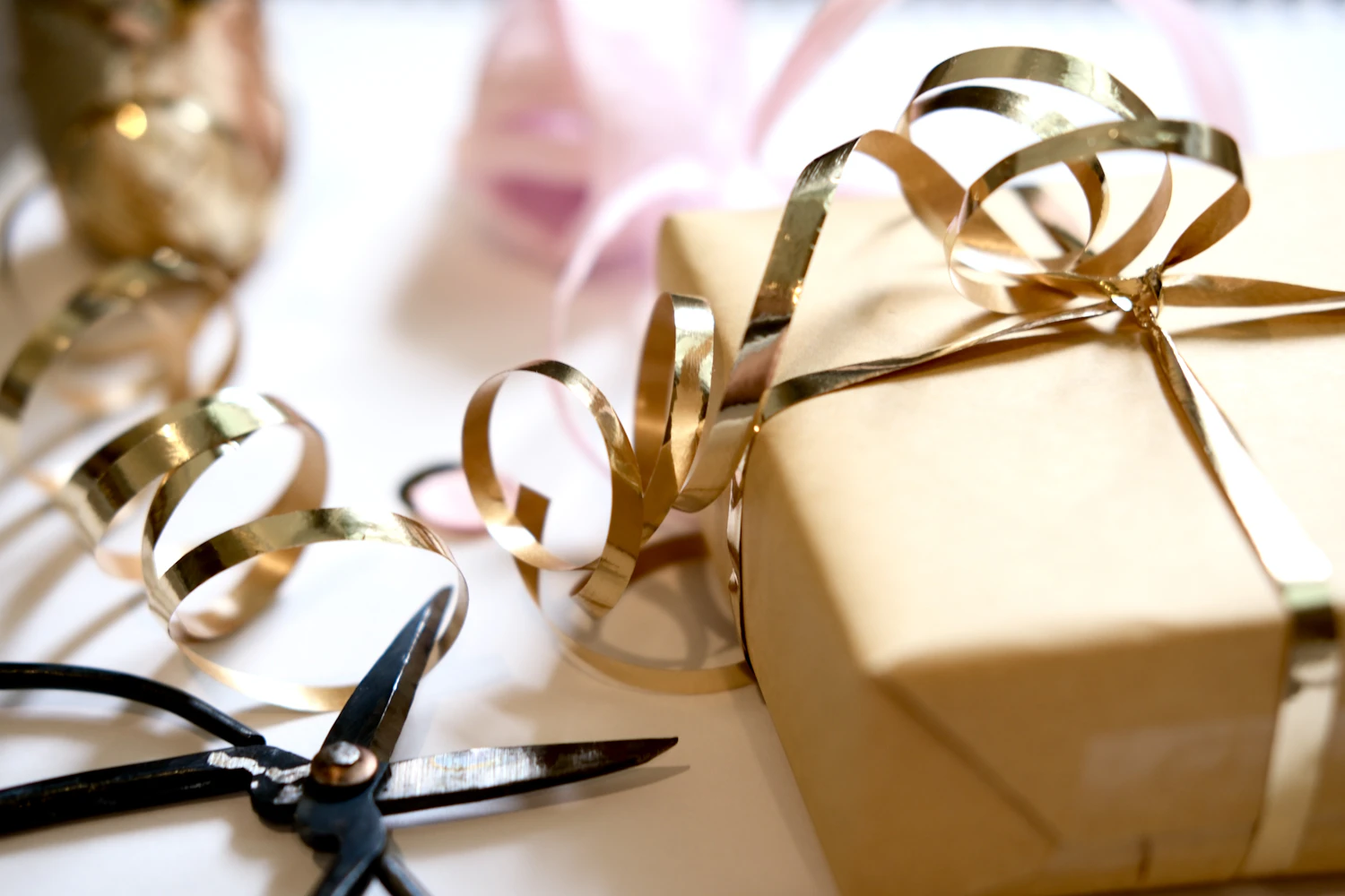 Gift wrapping materials arranged with ribbon, paper, and scissors