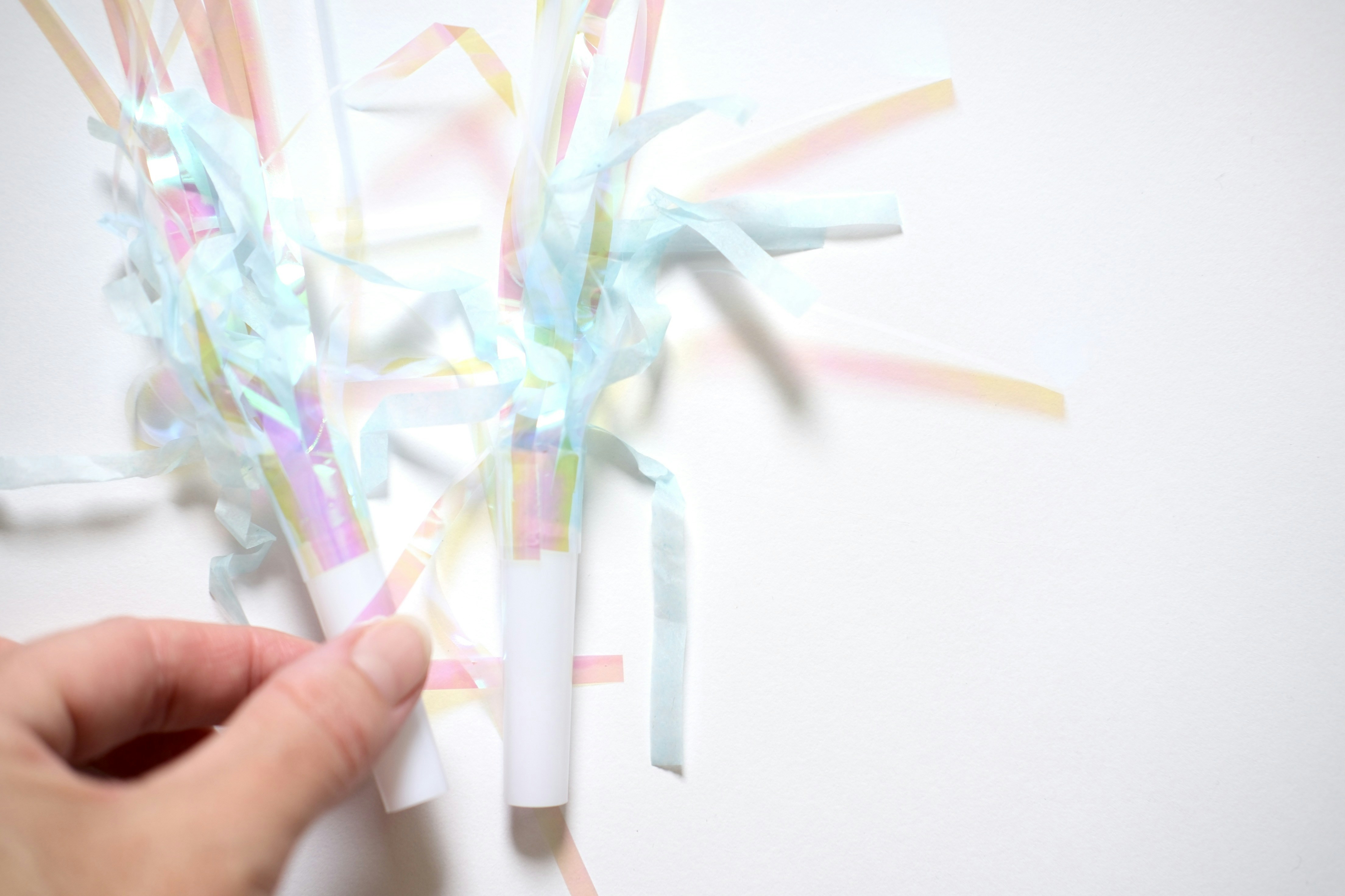 Pastel streamers on white background with hand