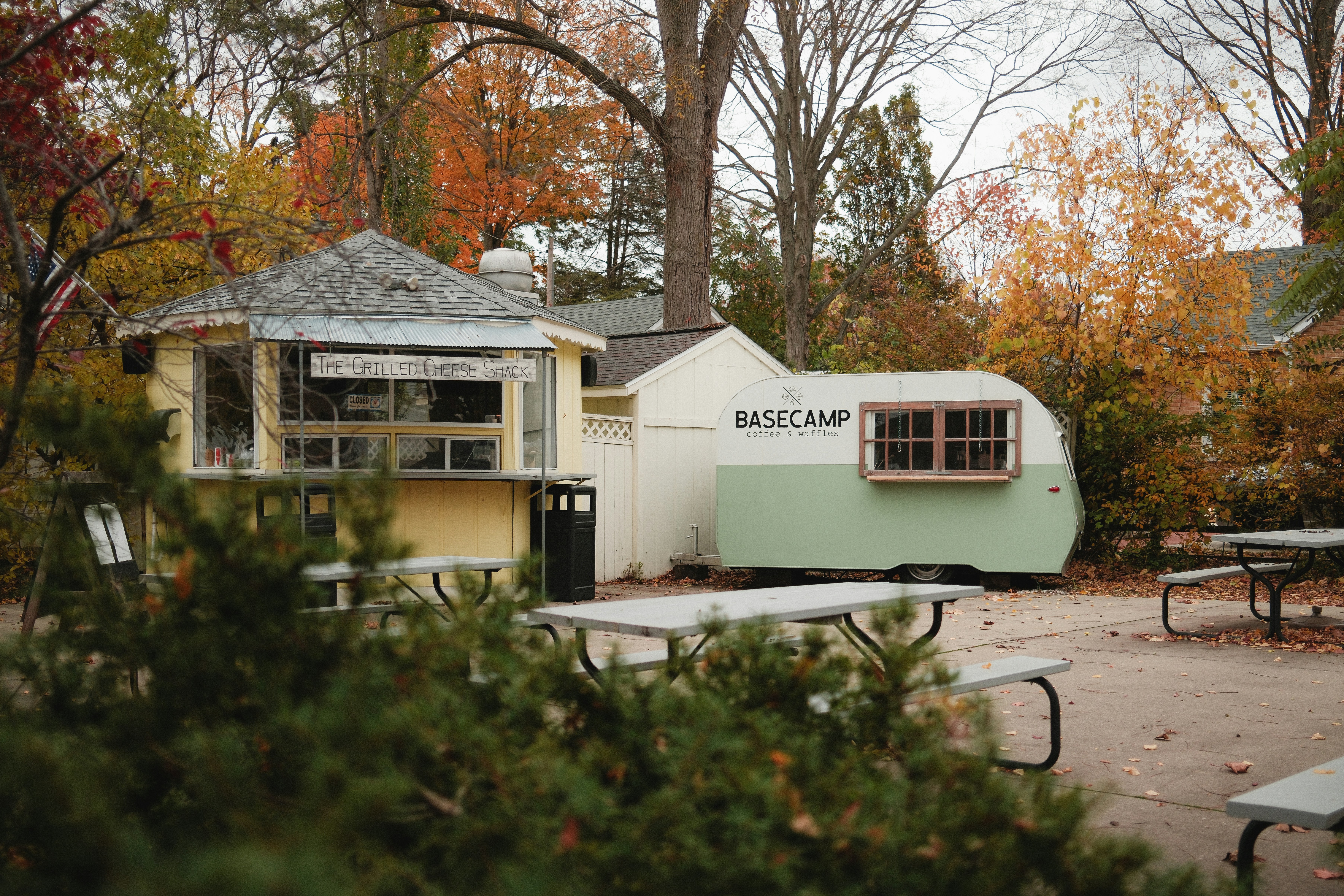Pequeño puesto de comida y remolque con mesas de picnic