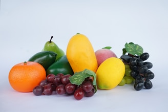 Assortment of fresh fruits including grapes, mango, and orange.