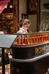 Woman behind a bar with bottles of orange liqueur